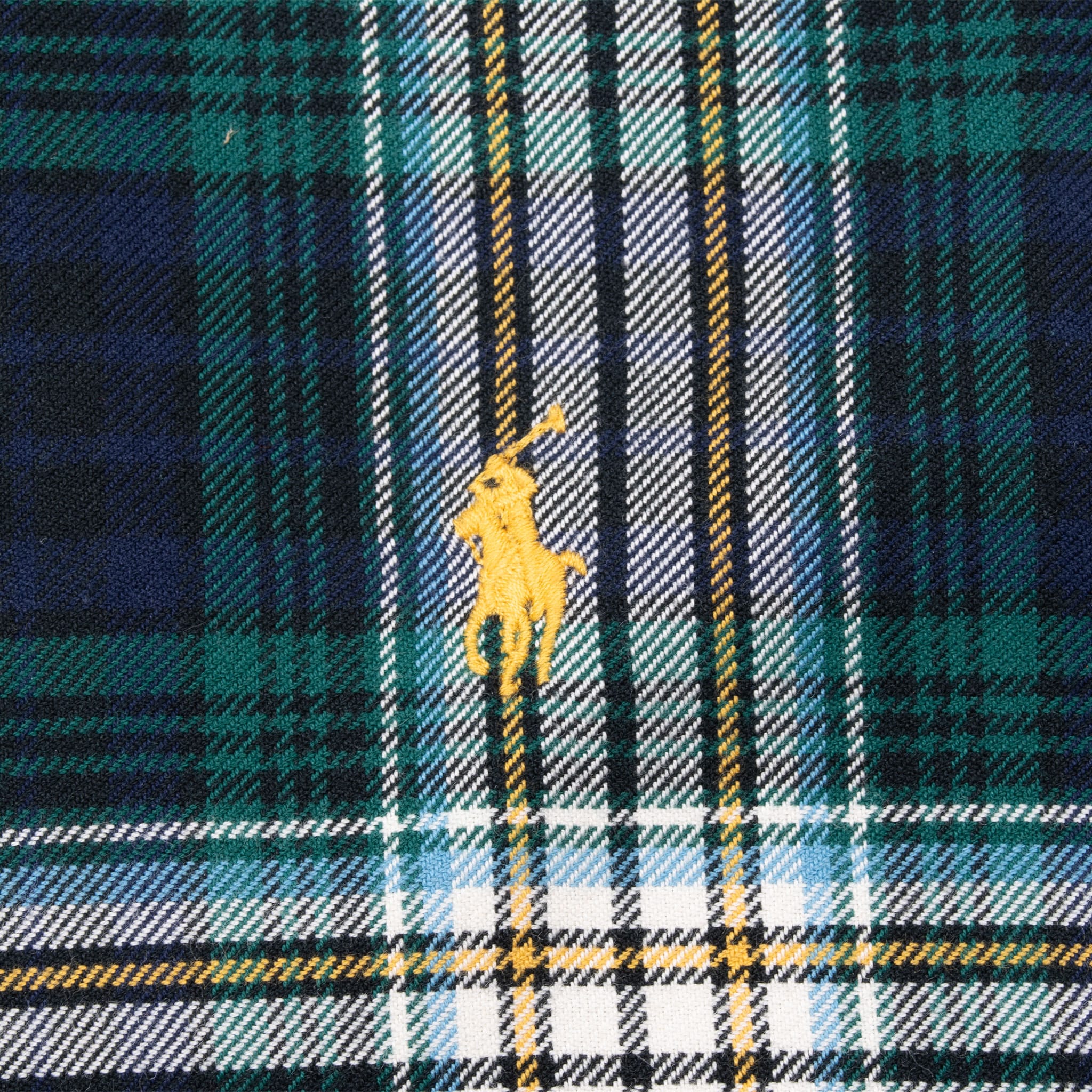 Close-up of yellow Polo pony embroidery on green plaid shirt chest