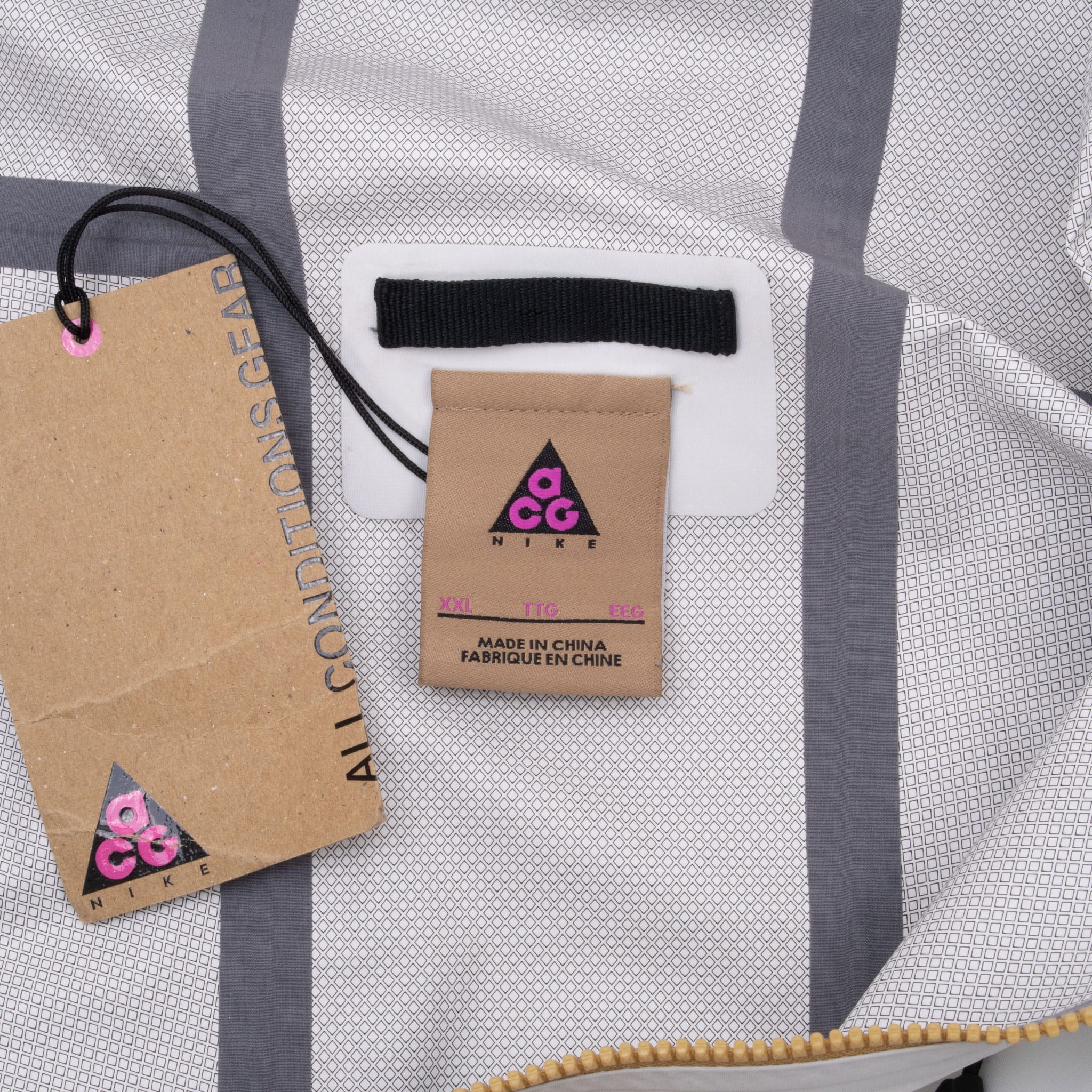 Nike ACG interior neck label and hangtag on mesh-patterned lining