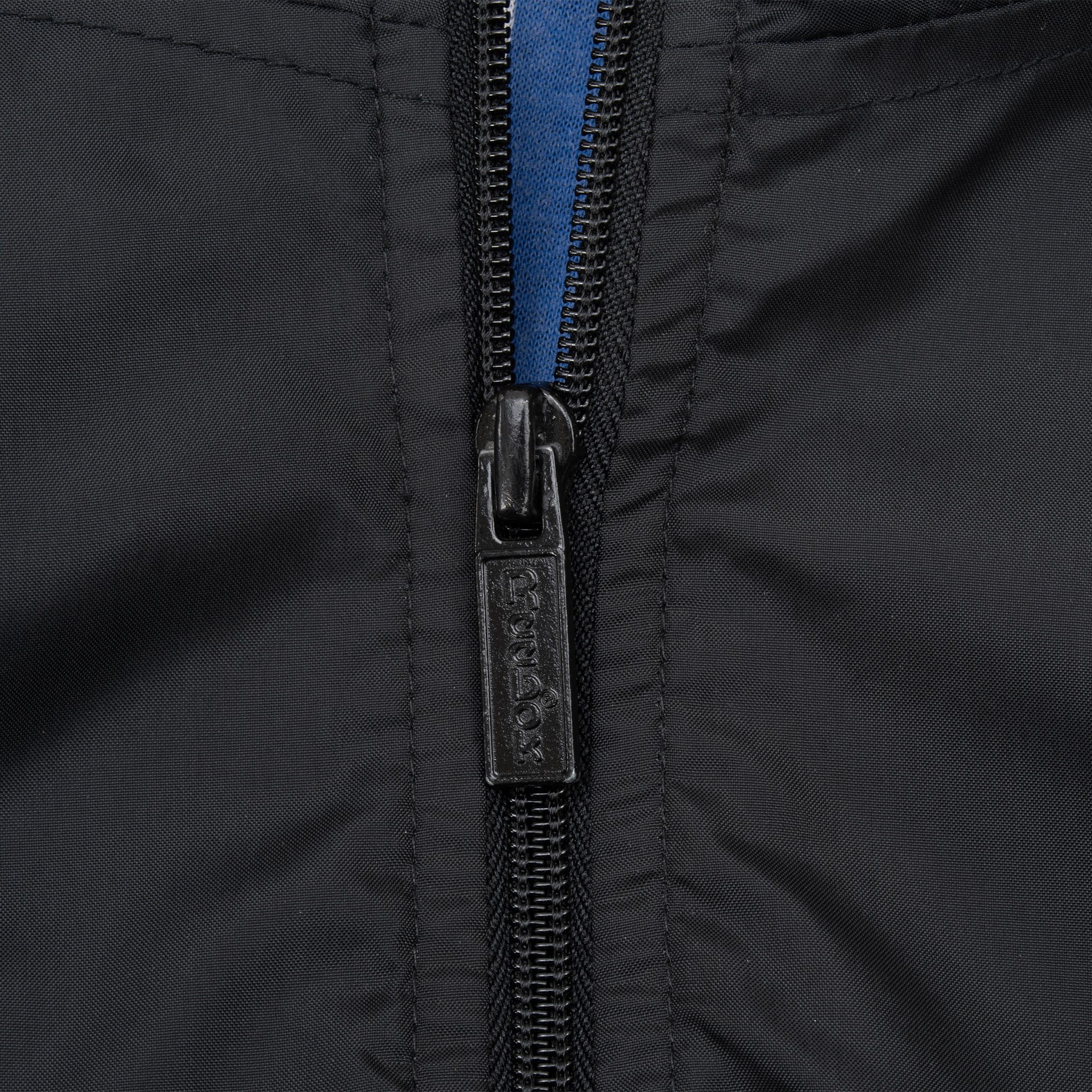 Close-up of black Reebok-branded front zipper pull