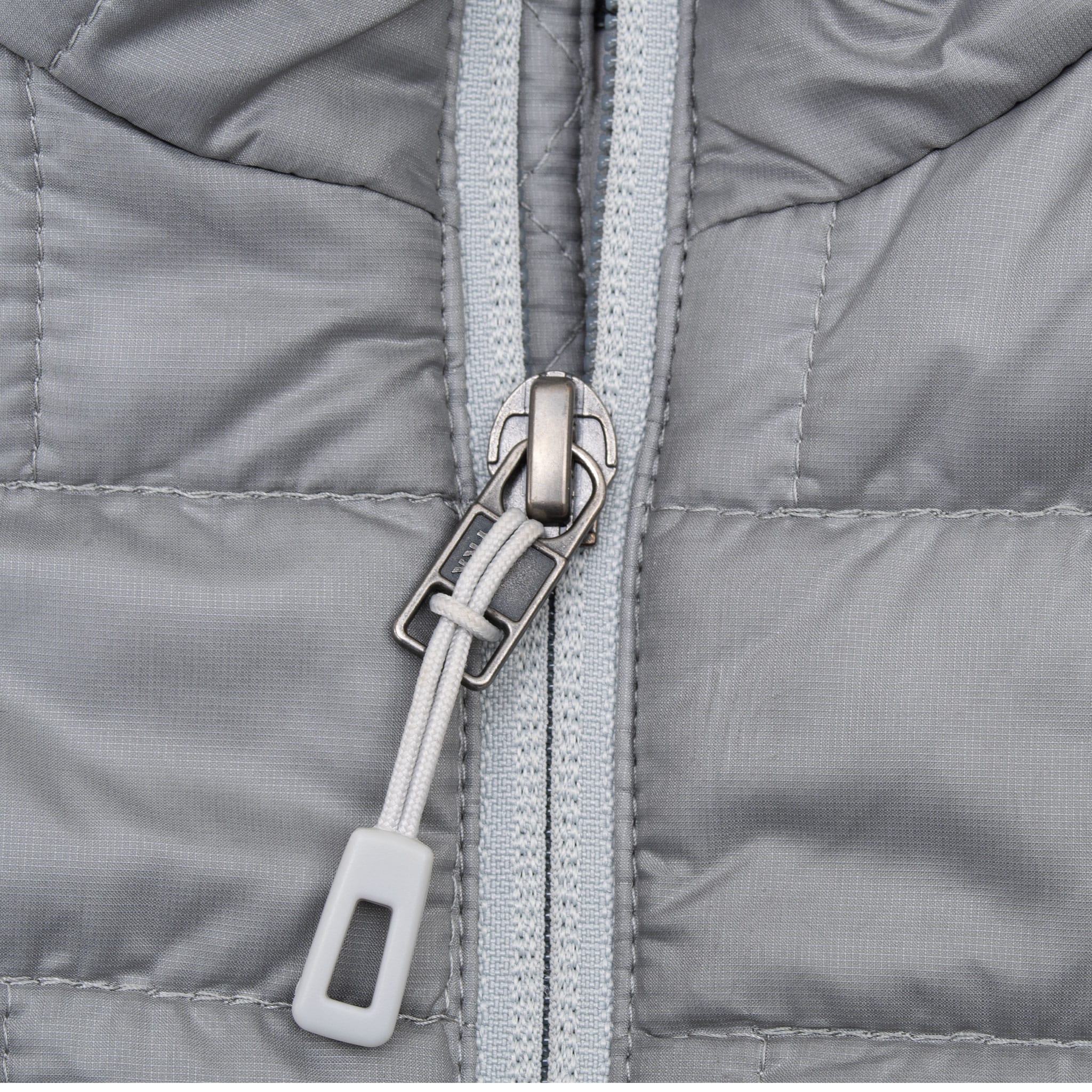 Close-up of light grey front zipper and pull tab on Patagonia Nano Puff jacket