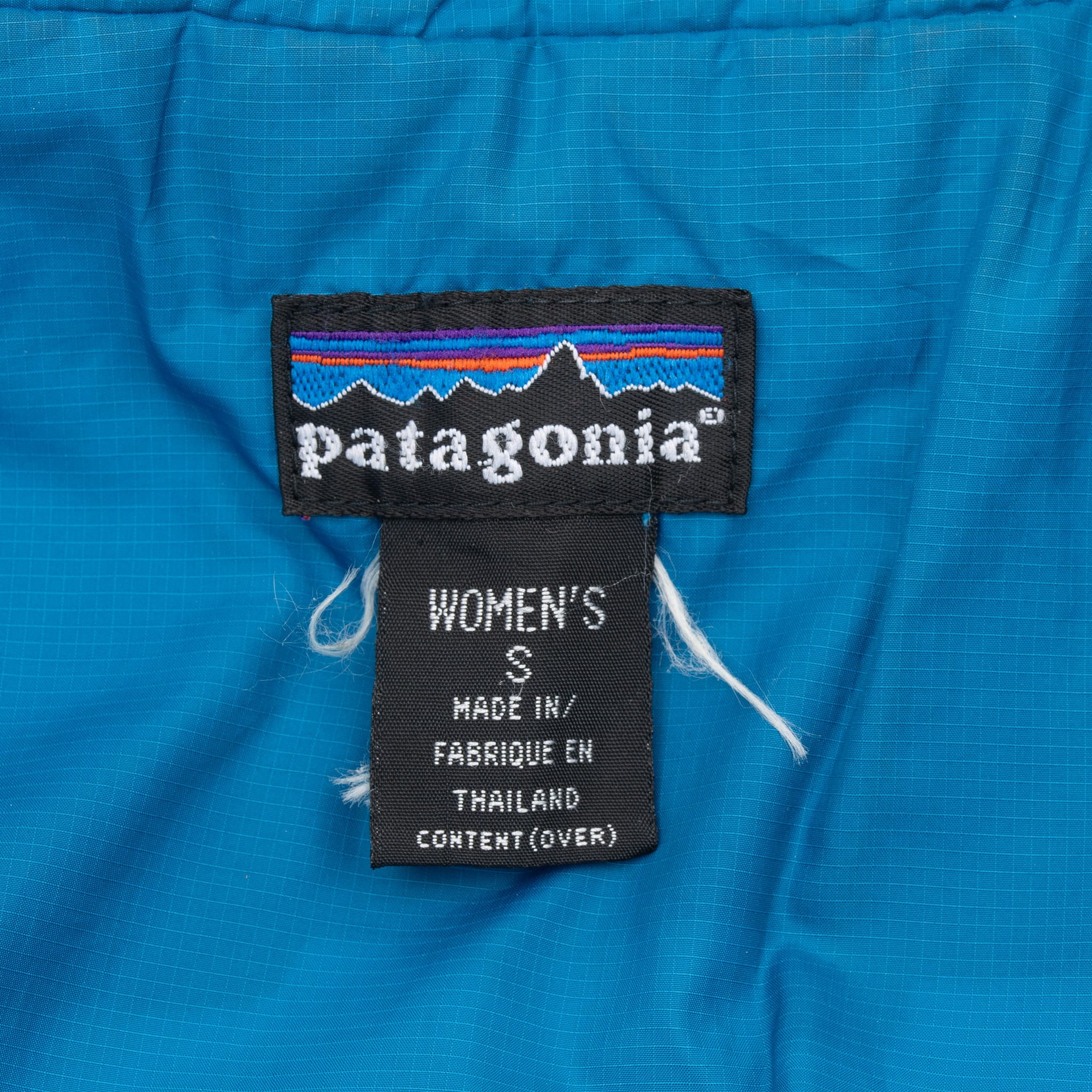 Patagonia neck label and women's size small tag on blue vest lining