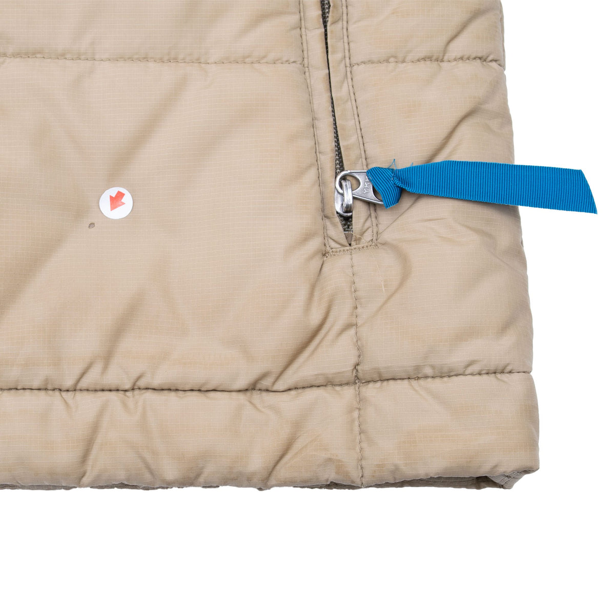 Close-up of small spot near zippered pocket and hem of beige Patagonia vest
