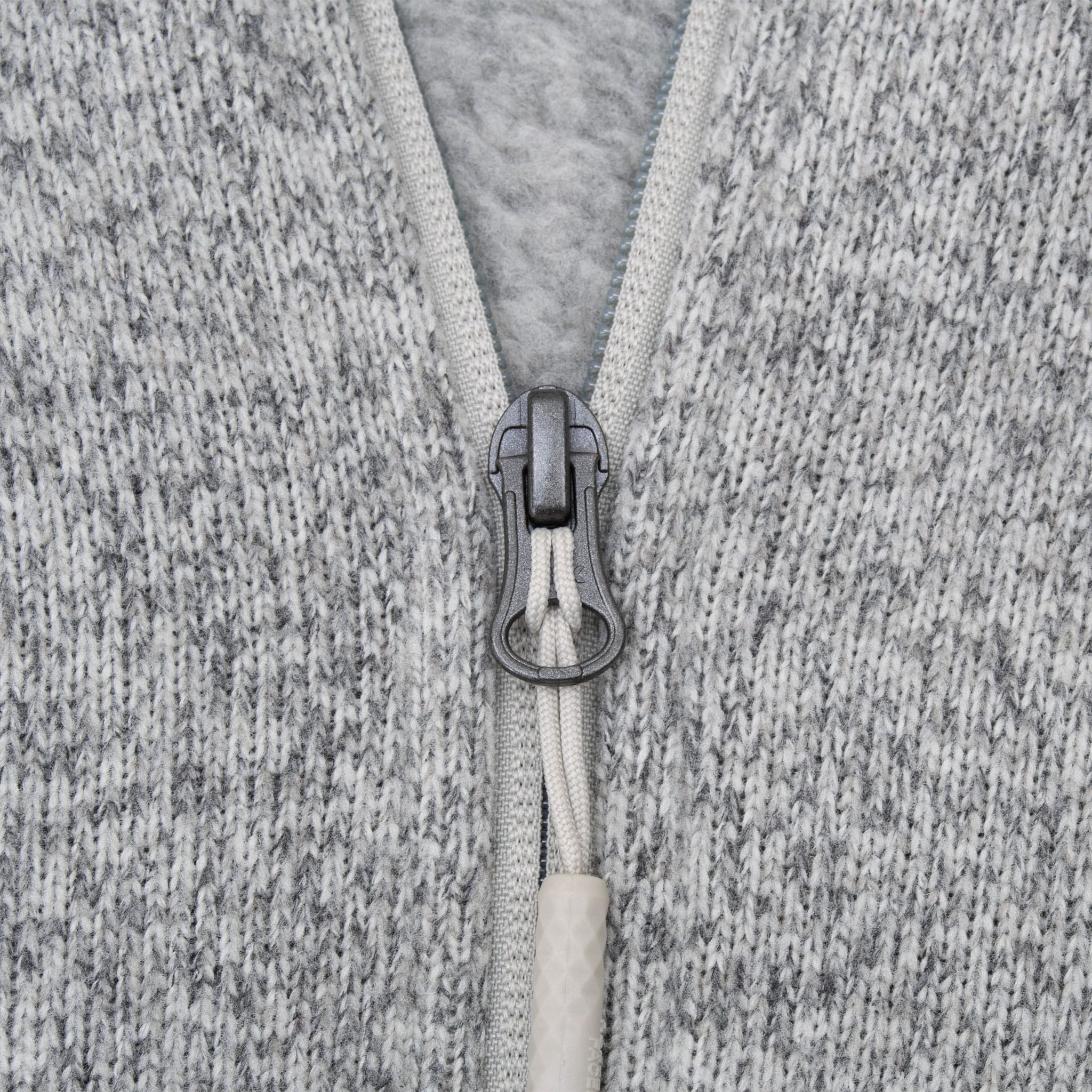 Close-up of quarter-zip closure and extended pull on grey Gordon Lyons jacket