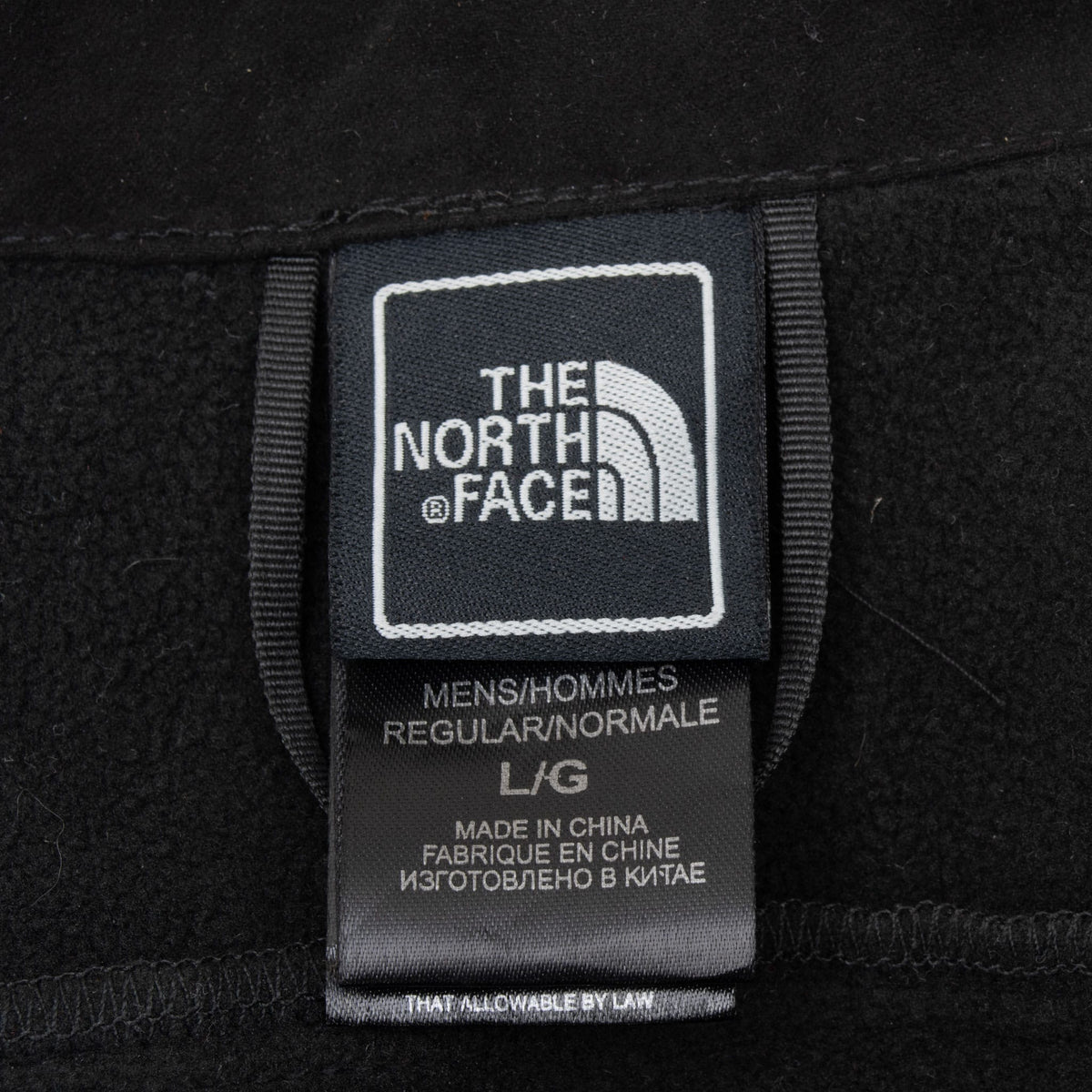 The North Face neck label on black fleece jacket showing men's size large