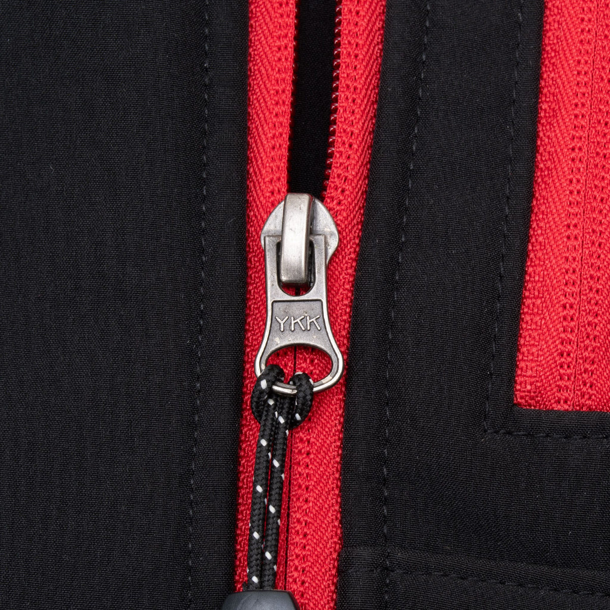 Close-up of red zipper tape and YKK zipper pull on black The North Face jacket
