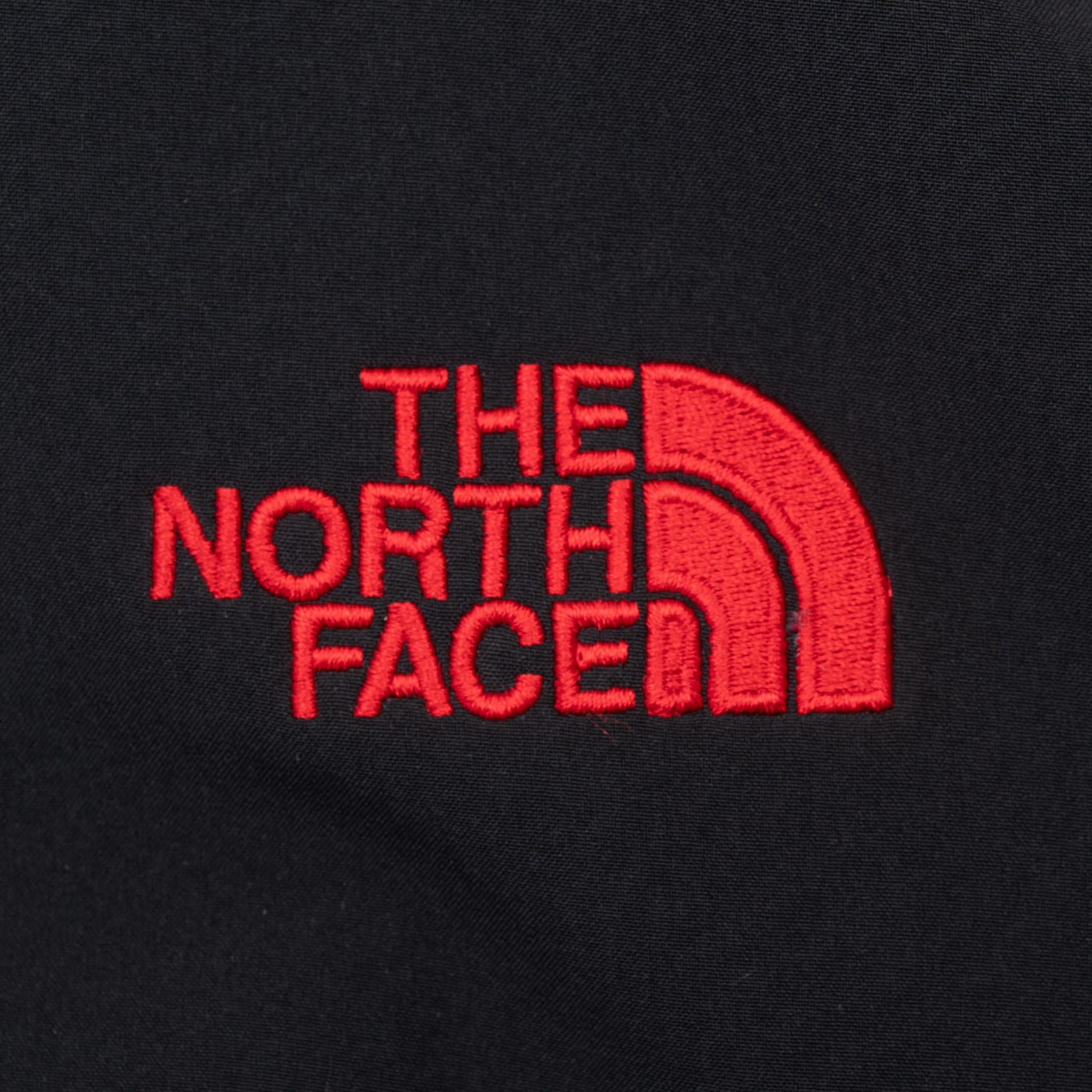 Close-up of red The North Face logo embroidery on black jacket