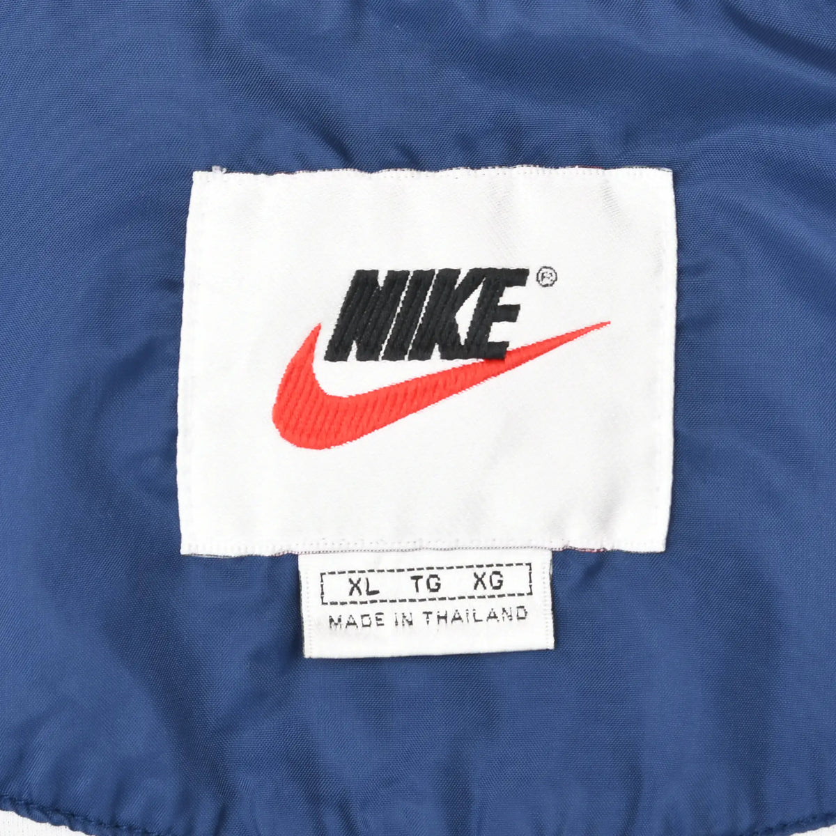 Nike neck label with black logo, red Swoosh, XL size marking, and Made in Thailand text