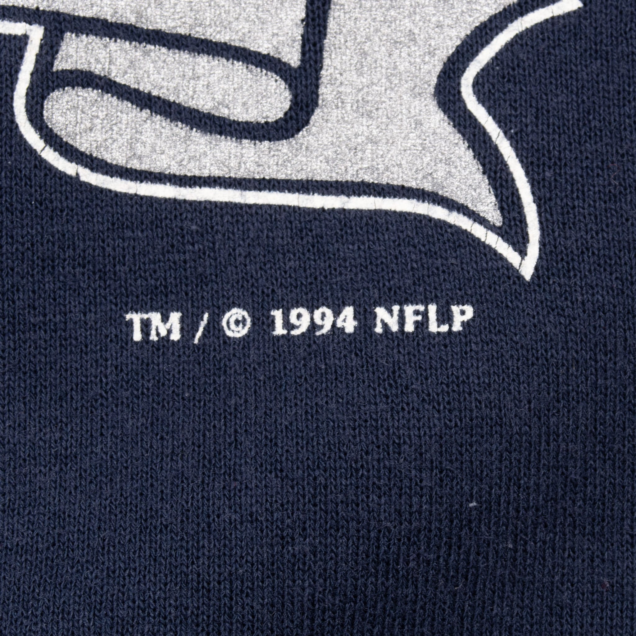 Close-up of TM and 1994 NFLP copyright print beneath the Dallas Cowboys graphic