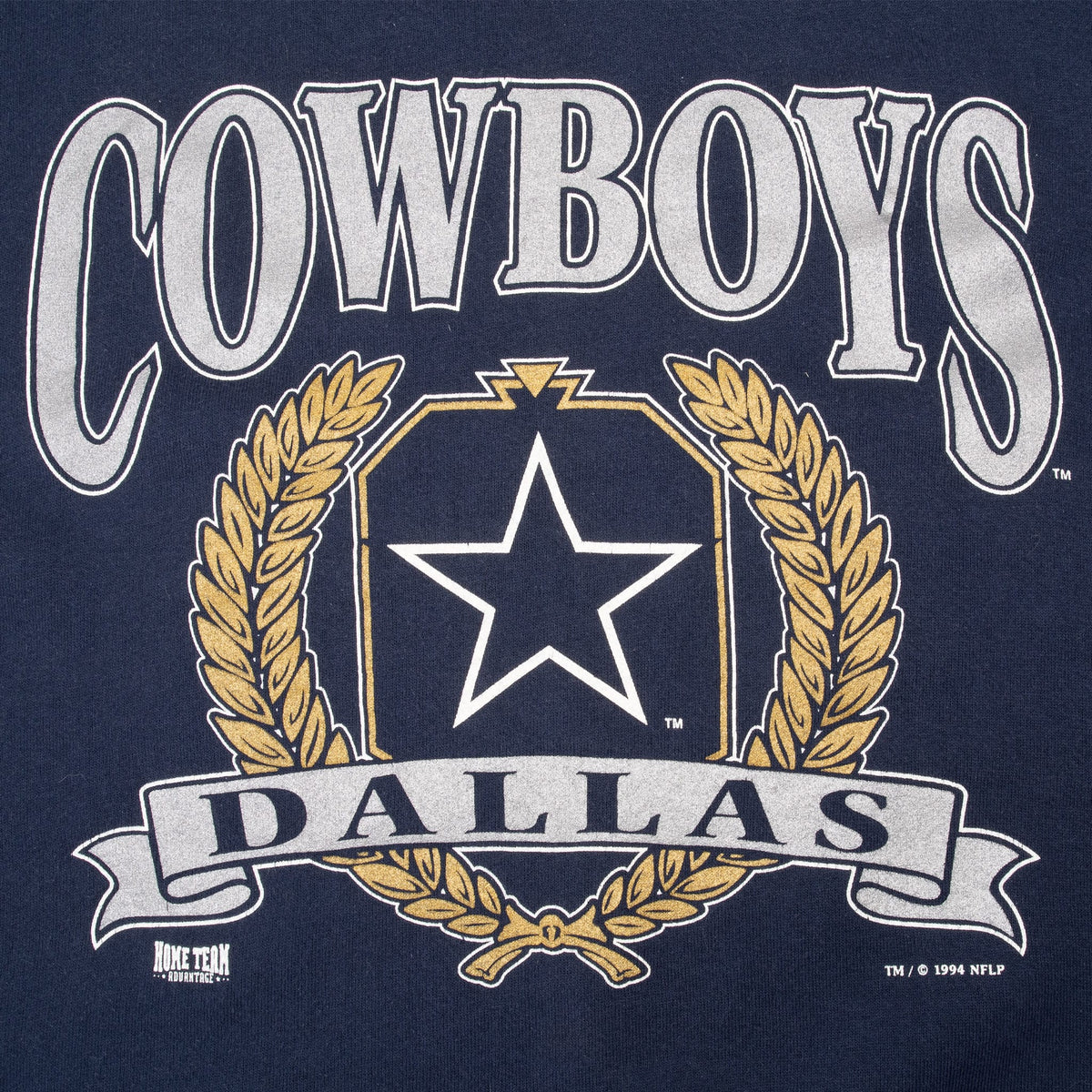 Close-up of Dallas Cowboys front graphic with silver lettering, star, gold wreath and banner