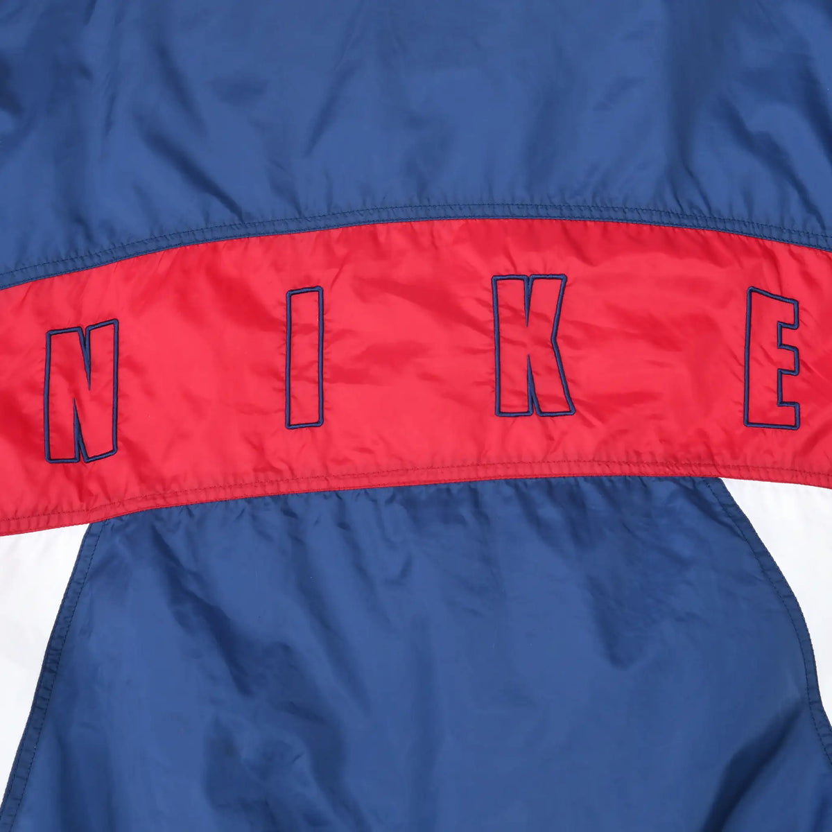 Close-up of outlined NIKE lettering across the red back stripe