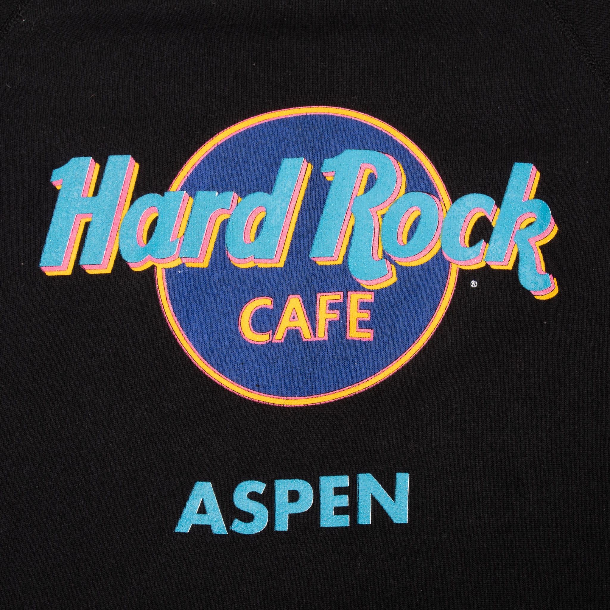 Close-up of blue, turquoise, pink and yellow Hard Rock Cafe Aspen front graphic