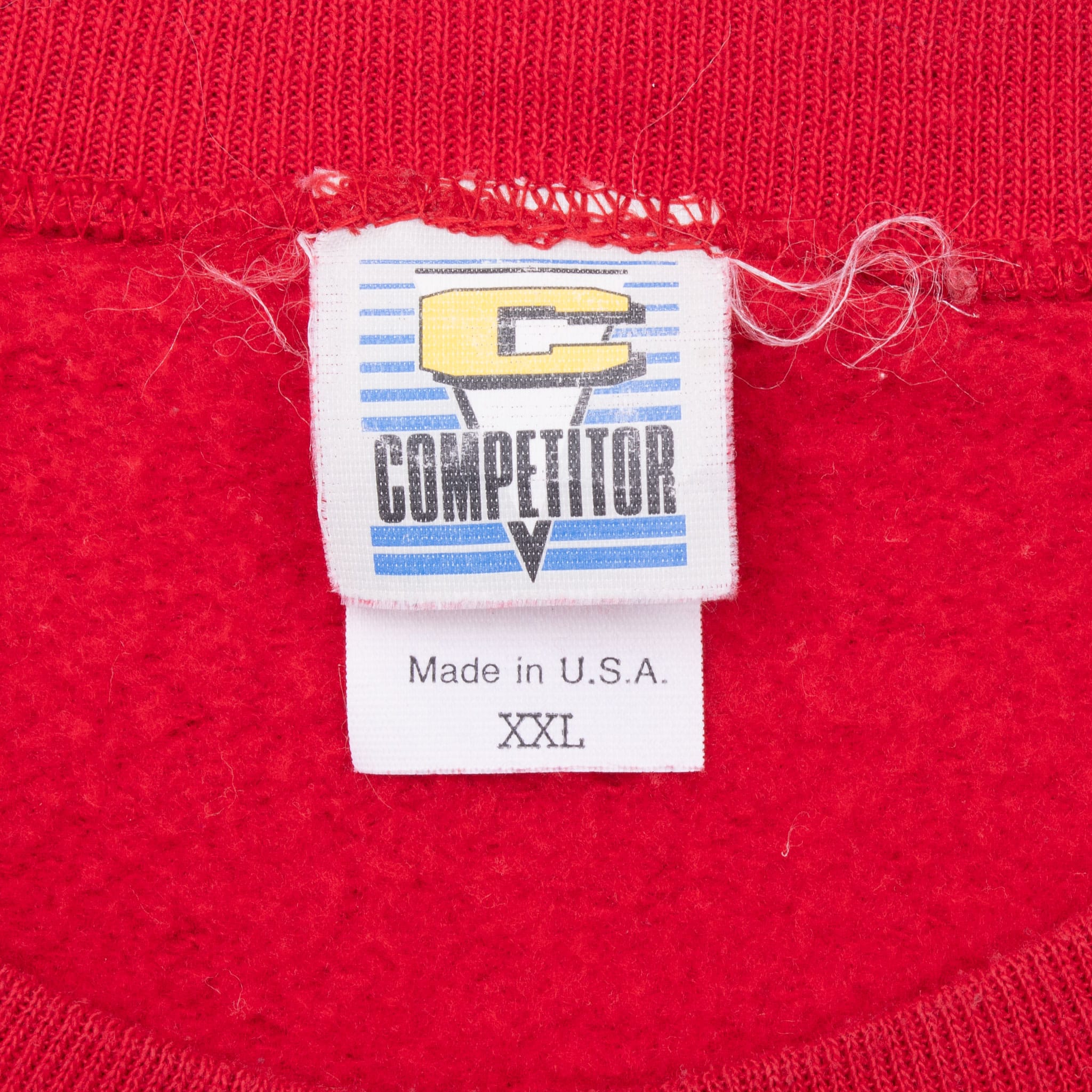 Competitor neck label on red sweatshirt showing XXL and Made in U.S.A.