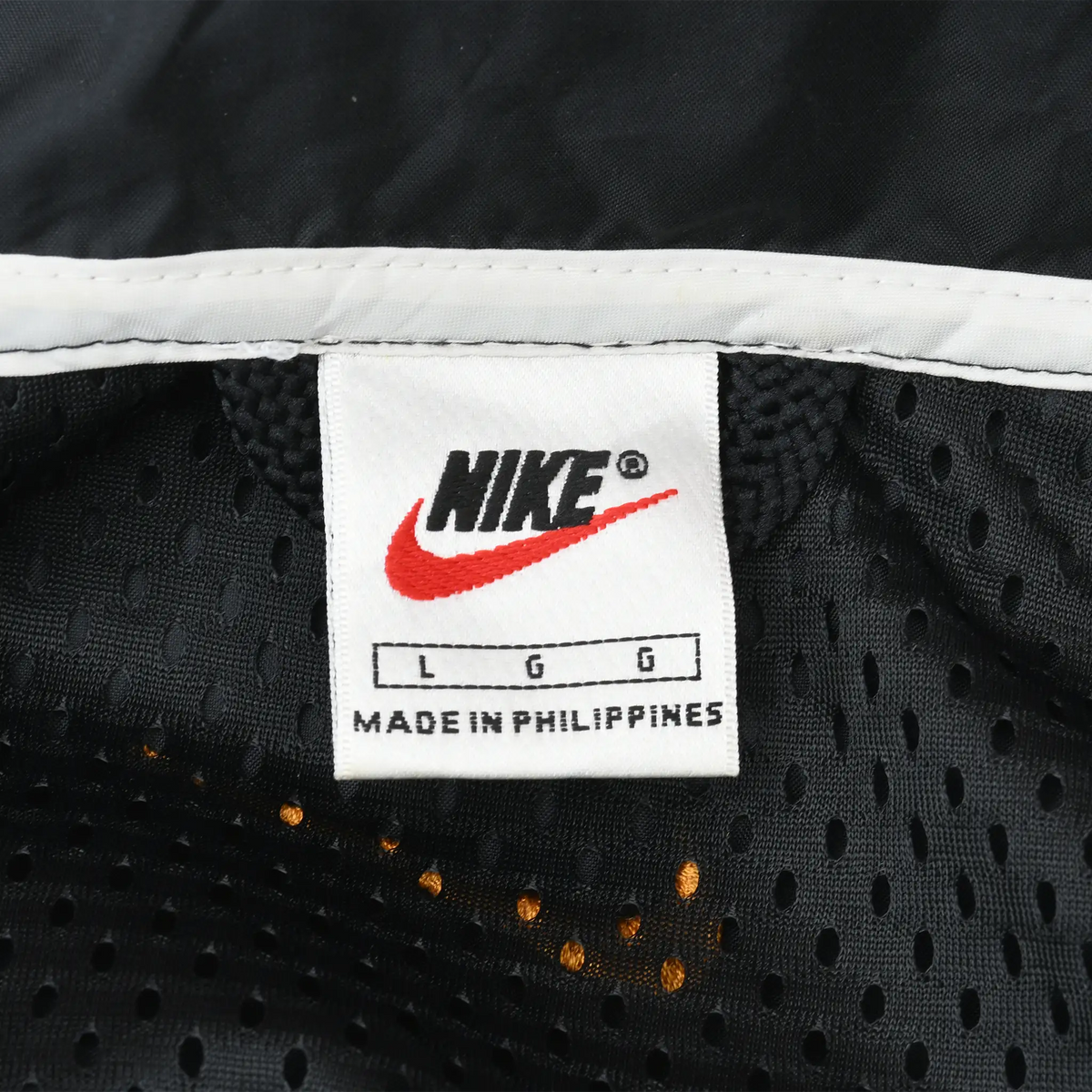 Nike neck label marked size L inside black mesh-lined windbreaker