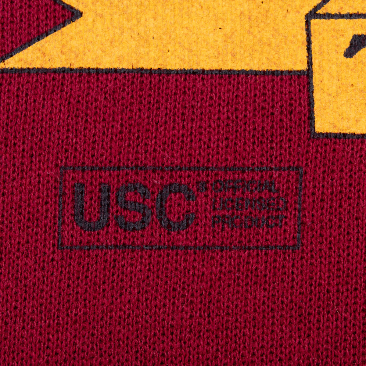 Close-up of USC licensing mark beneath the front graphic on cardinal red fabric