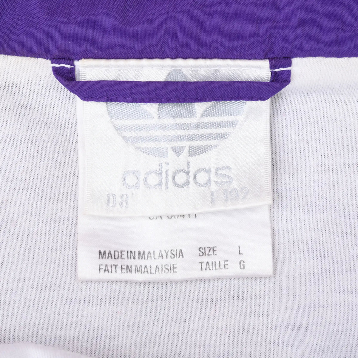 Adidas Trefoil neck label and size L tag inside the purple windbreaker