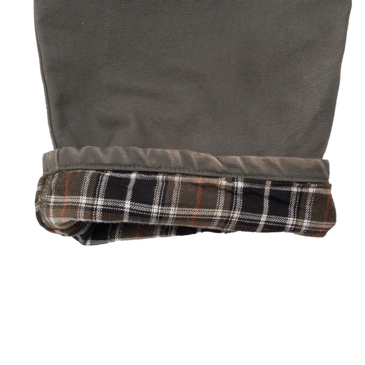 Rolled green pant cuff showing black, white and red plaid flannel lining