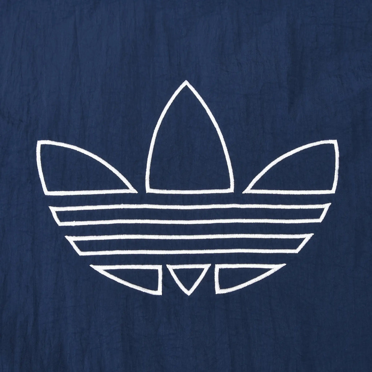 Close-up of large white outlined Adidas Trefoil logo on the navy back panel