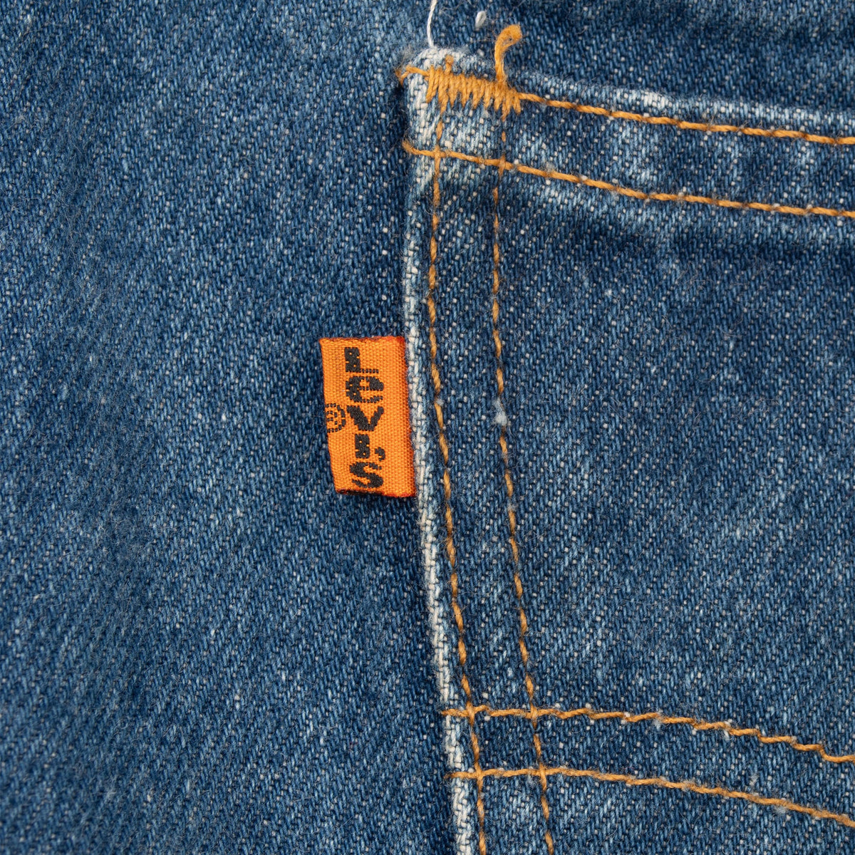 Close-up of orange Levi's tab beside the rear pocket seam