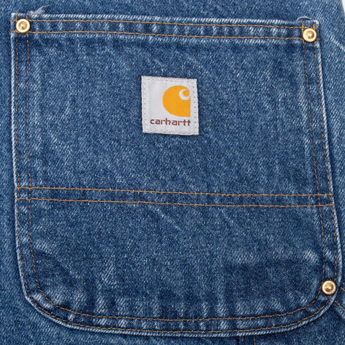 Carhartt logo patch on riveted rear pocket of blue carpenter jeans