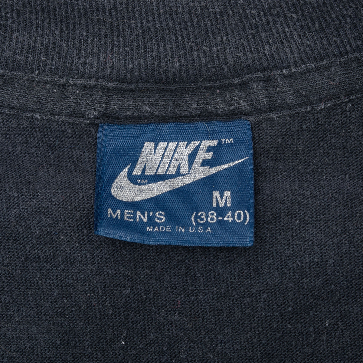 Close-up of blue Nike men's medium neck label marked Made in USA