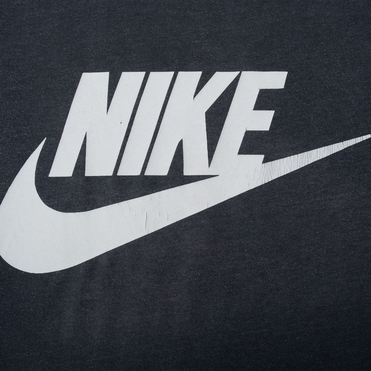 Close-up of white Nike logo and Swoosh print on black fabric