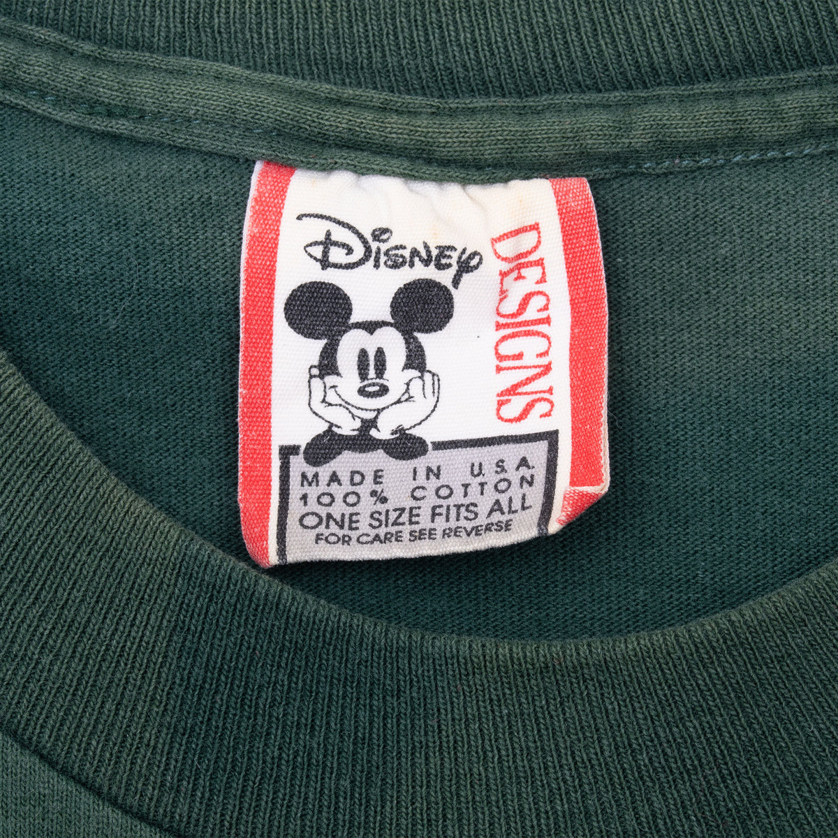Disney Designs neck tag with Mickey Mouse on dark green tee