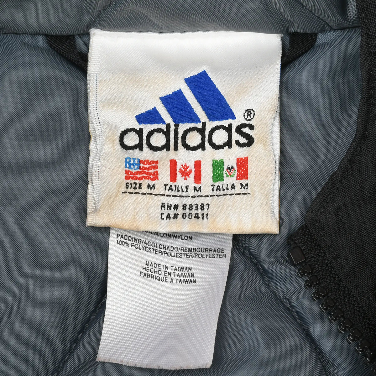 Close-up of Adidas neck label showing medium size and nylon fabric details
