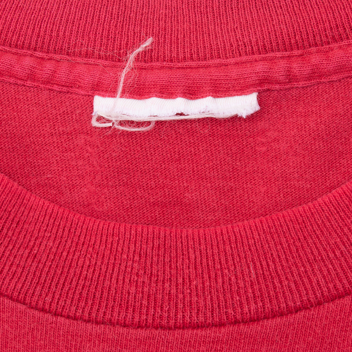 Close-up of red ribbed collar and faded neck tag