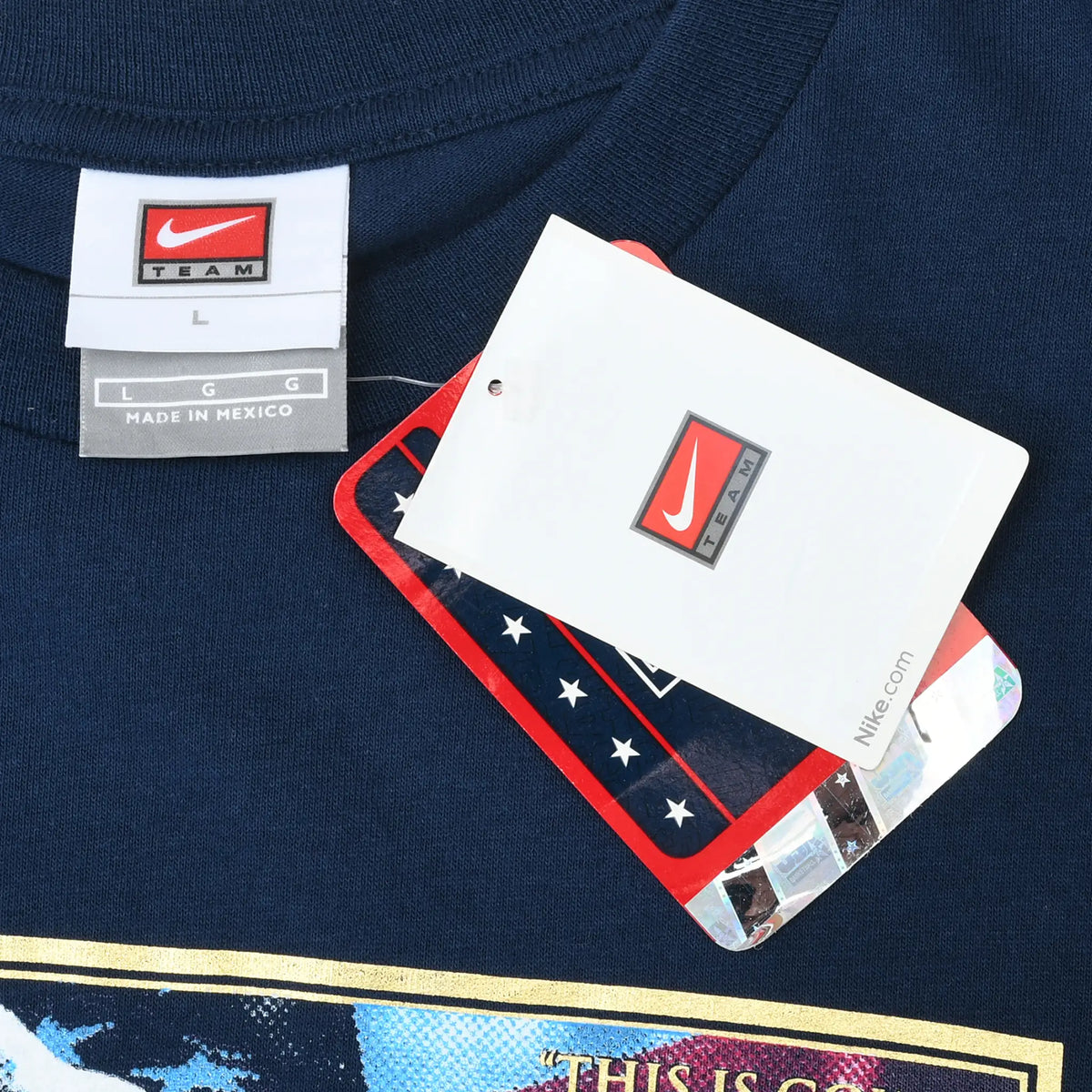 Close-up of Nike Team neck label and attached hangtags on navy T-shirt