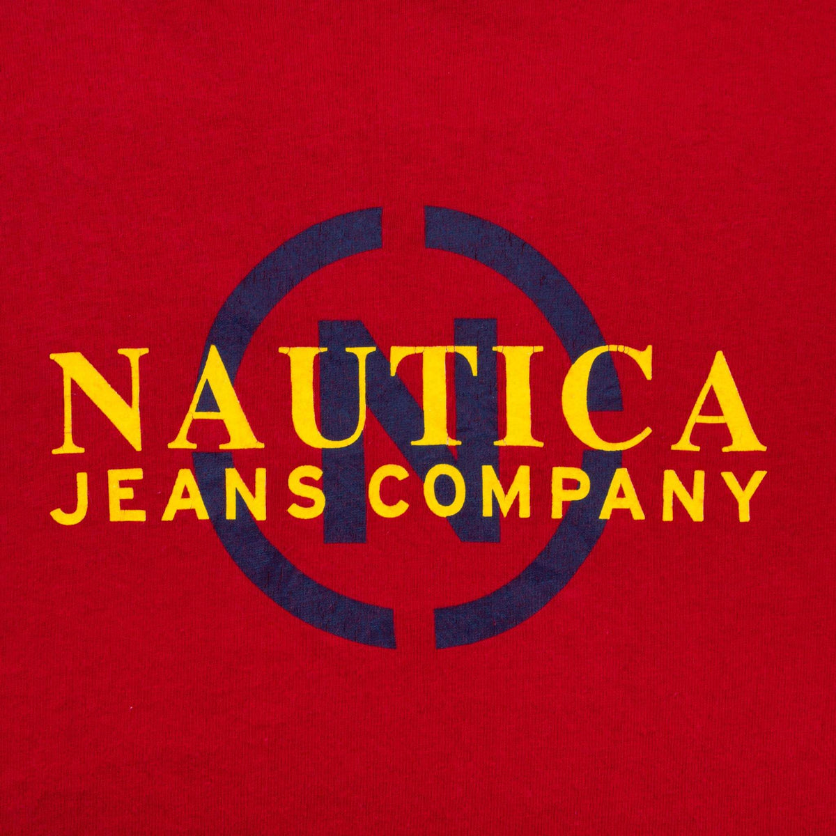 Close-up of yellow and navy Nautica Jeans Company chest print on red fabric