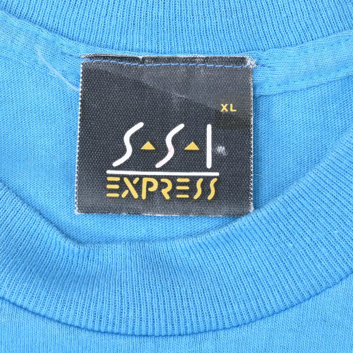 Close-up of black SSI Express XL neck label on blue T-shirt