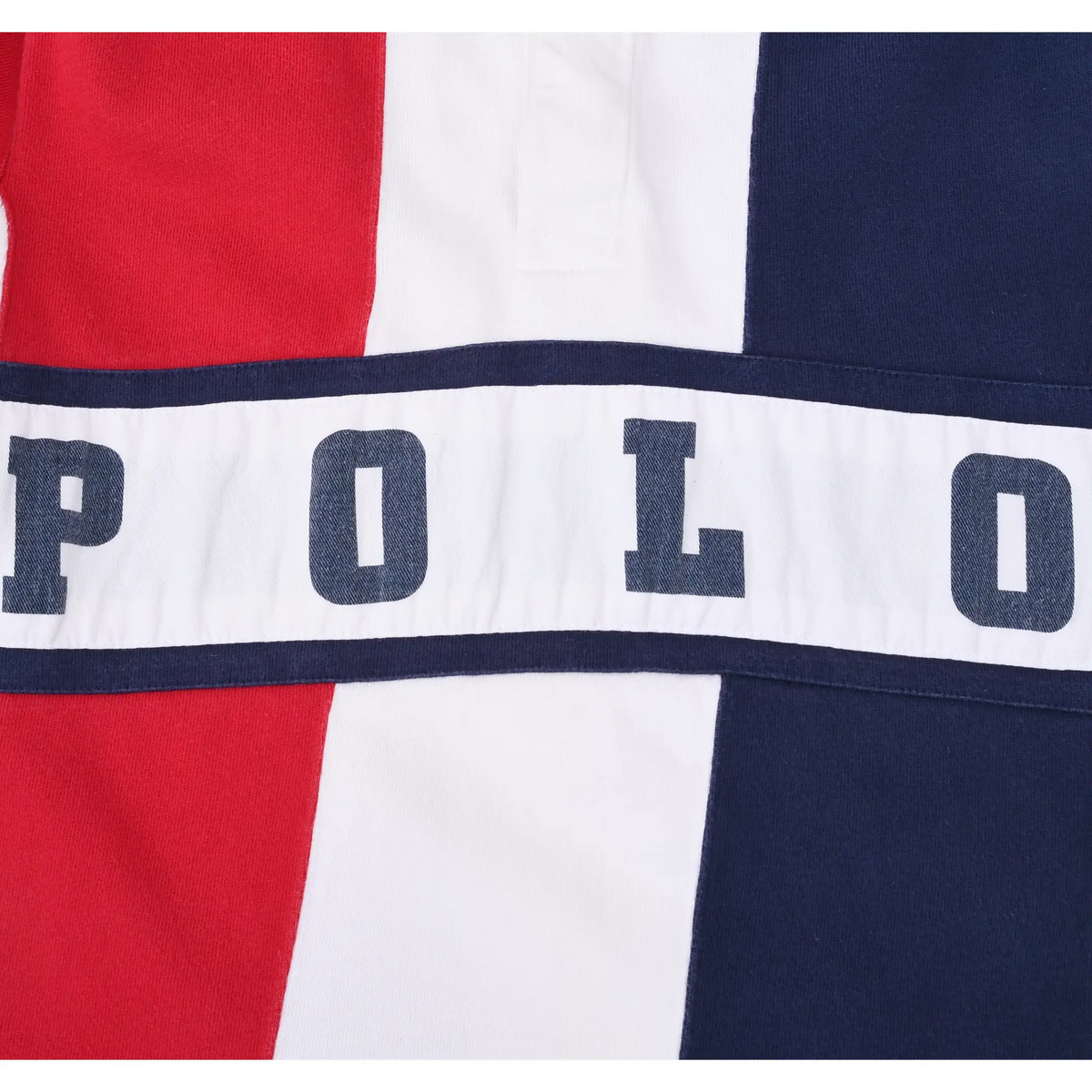 Close-up of navy POLO lettering across the white chest stripe and red, white and navy panels