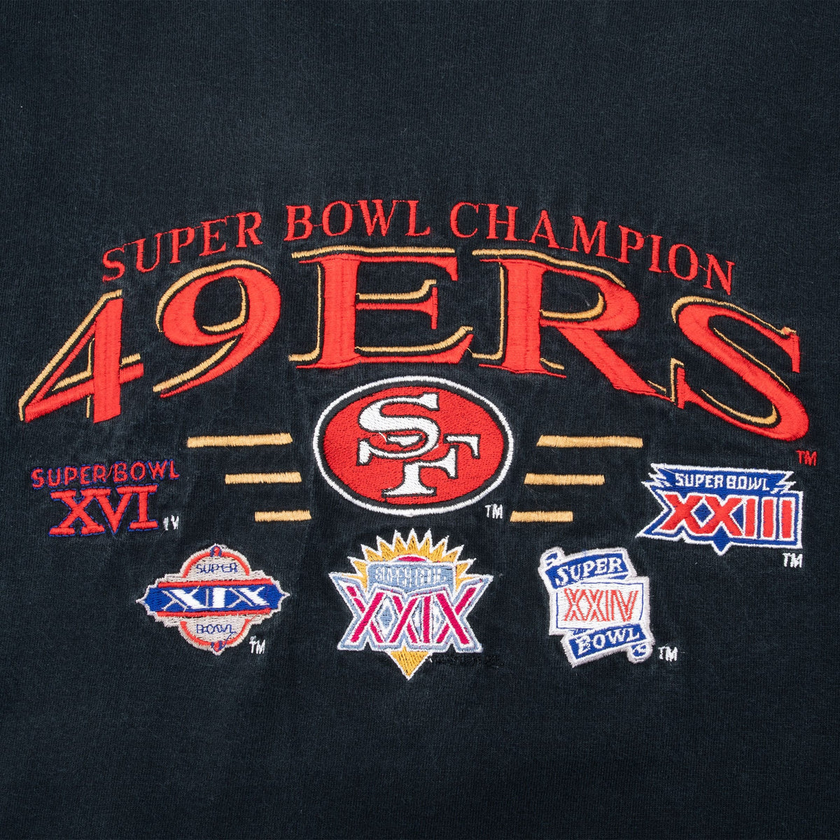 Close-up of 49ers Super Bowl Champions graphic with SF logo and five Super Bowl emblems
