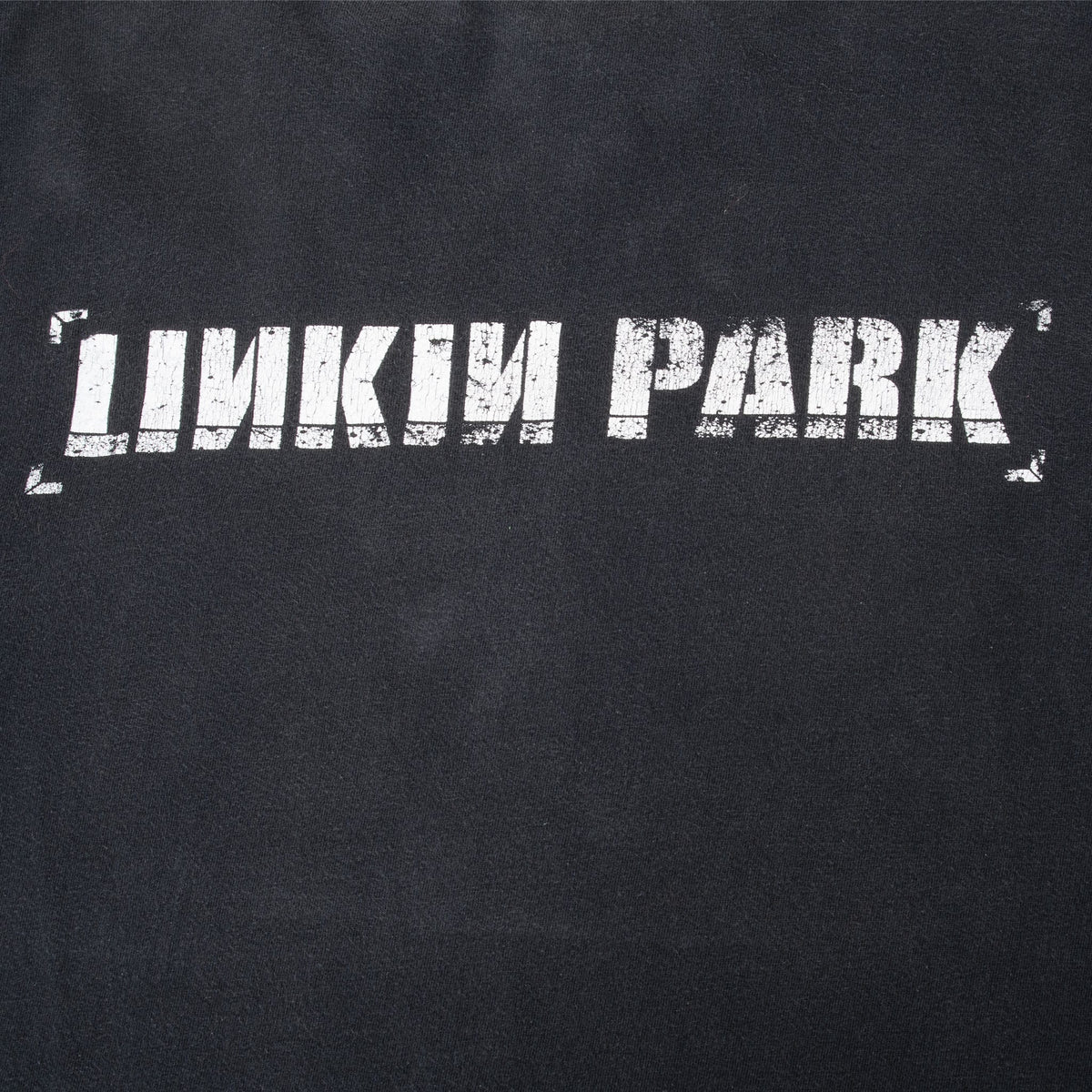 Close-up of distressed white Linkin Park name graphic on the upper back