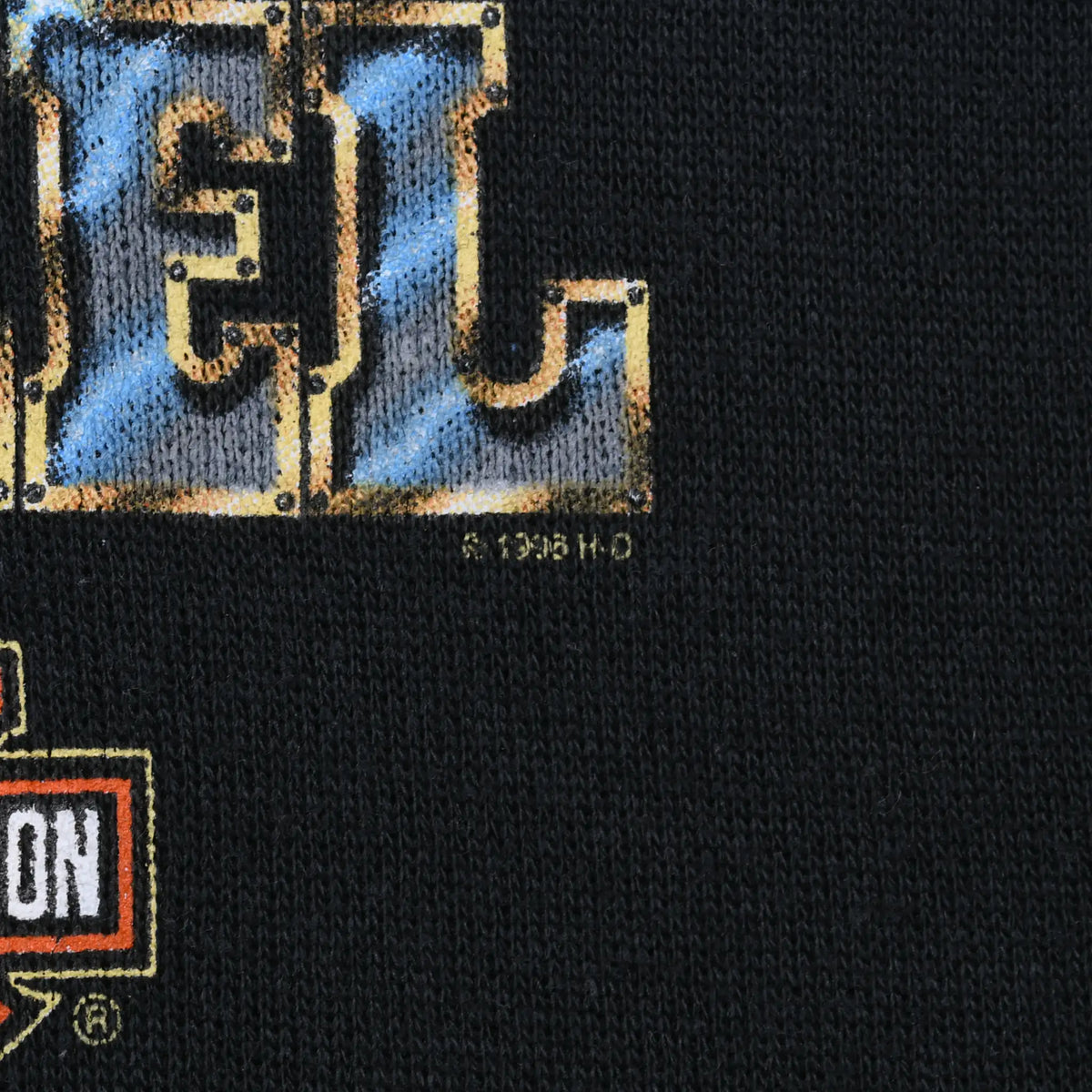 Close-up of Real Steel print edge, copyright mark, and Harley-Davidson logo on black fabric