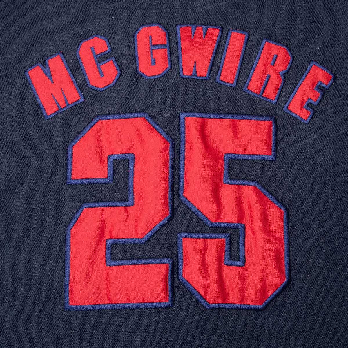 Close-up of red McGwire lettering and number 25 with navy outlines on jersey back
