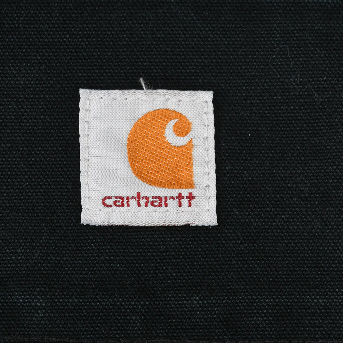 Close-up of Carhartt logo patch on black fabric