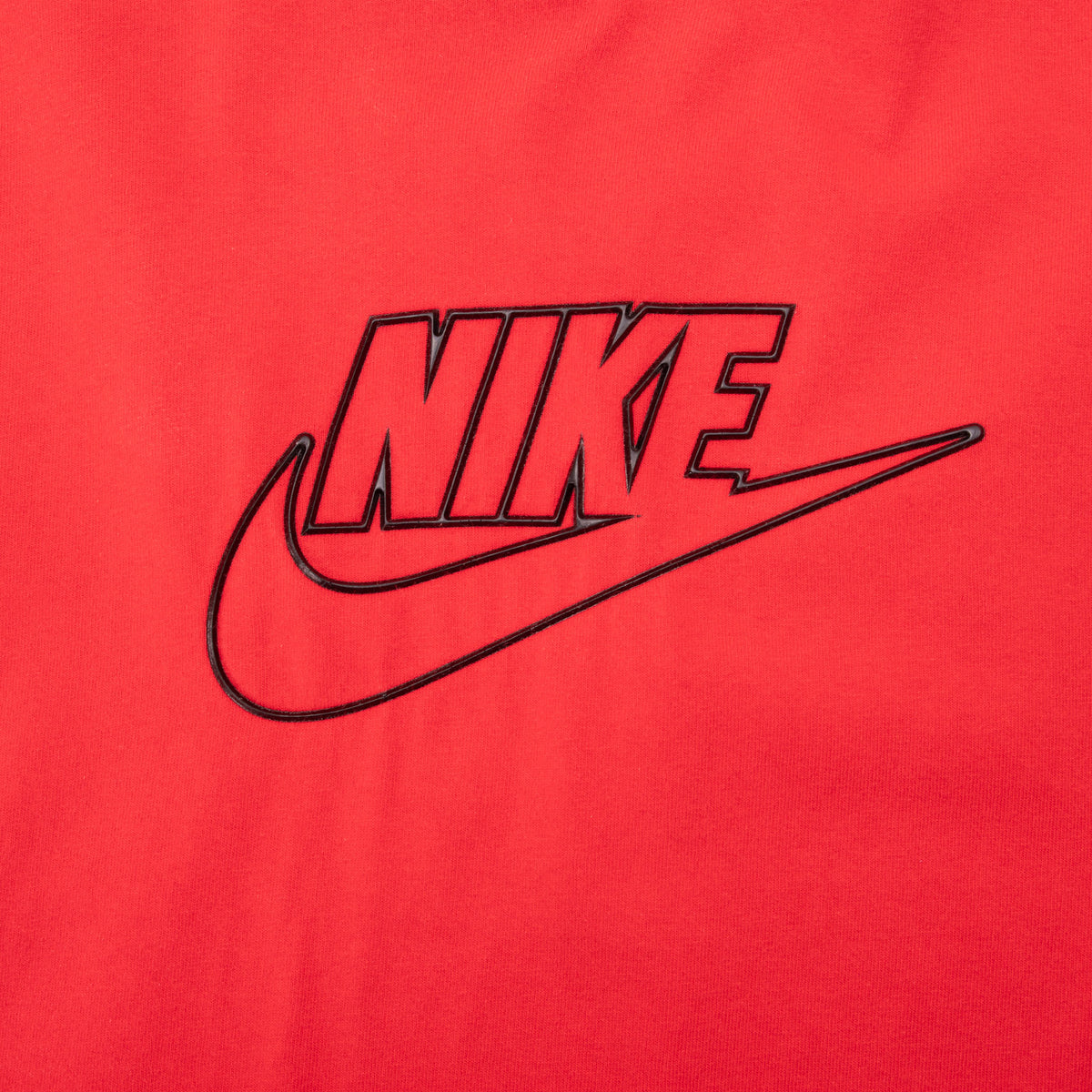 Close-up of black outlined Nike spellout and Swoosh graphic on red fabric