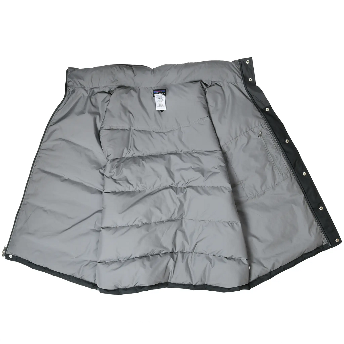 Open Patagonia down vest showing gray quilted lining, interior pocket, label, and snap closure