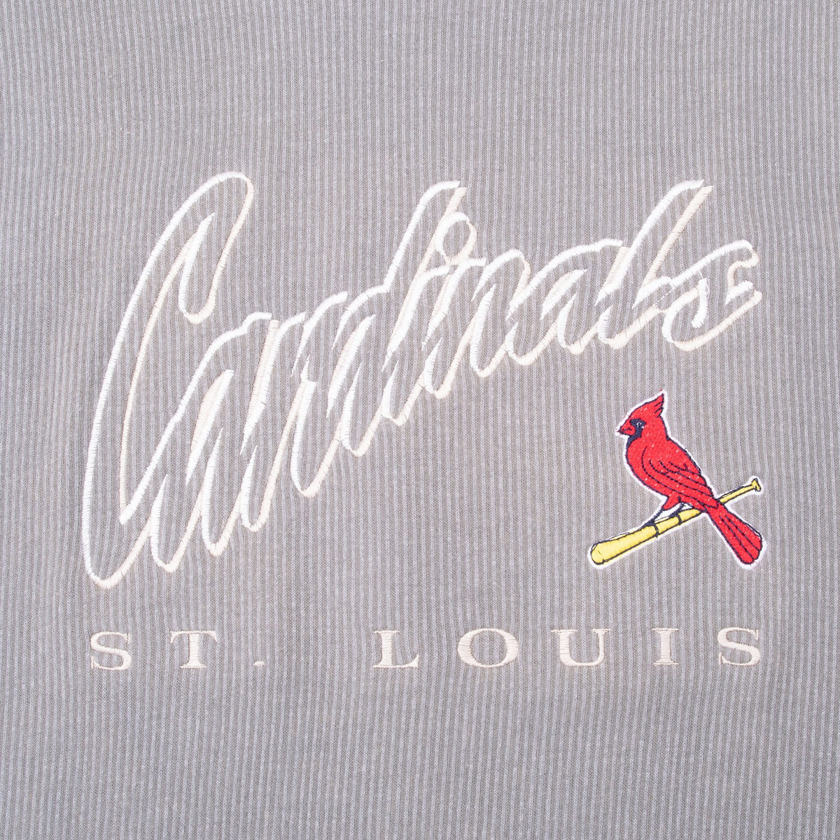 Close-up of embroidered Cardinals script, red cardinal-on-bat emblem, and St. Louis lettering