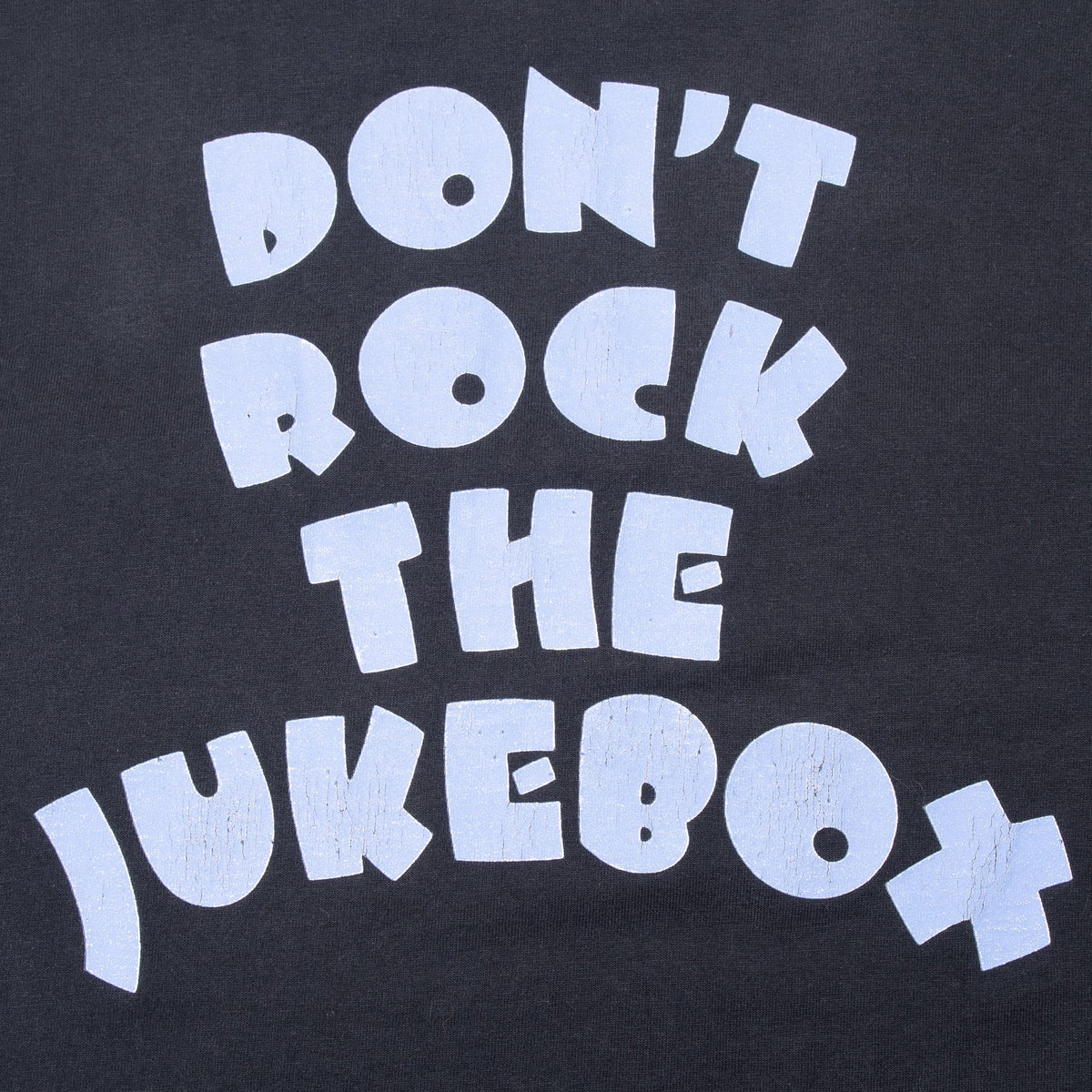 Close-up of light blue Don't Rock the Jukebox back print on black fabric