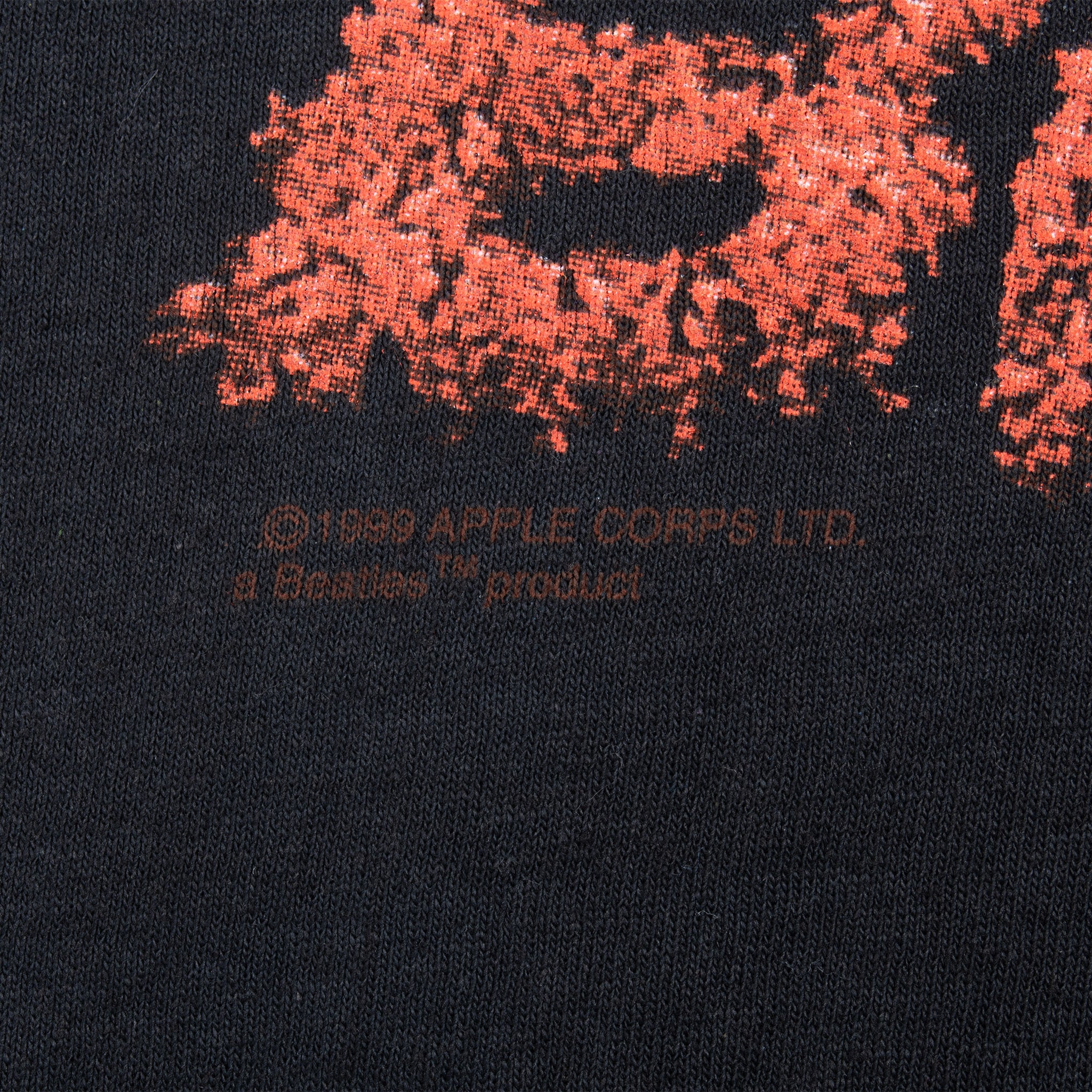 Close-up of Apple Corps copyright and Bravado product text beneath front print