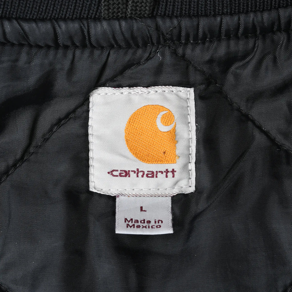 Close-up of Carhartt neck label and large size tag on black quilted lining