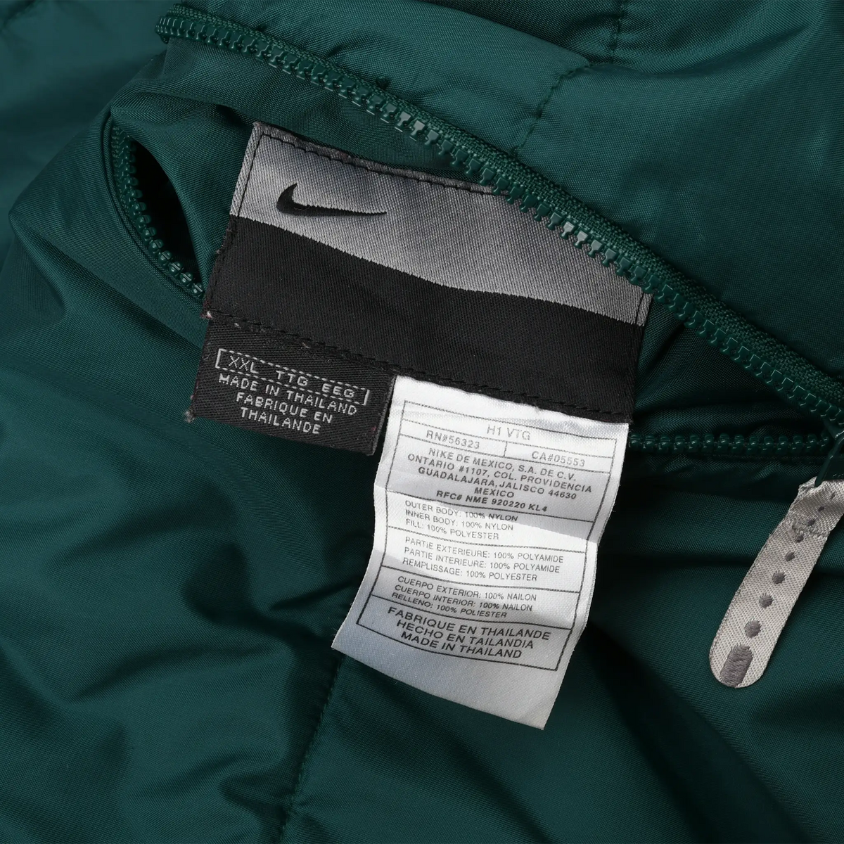 Close-up of Nike garment and care labels inside the dark green windbreaker