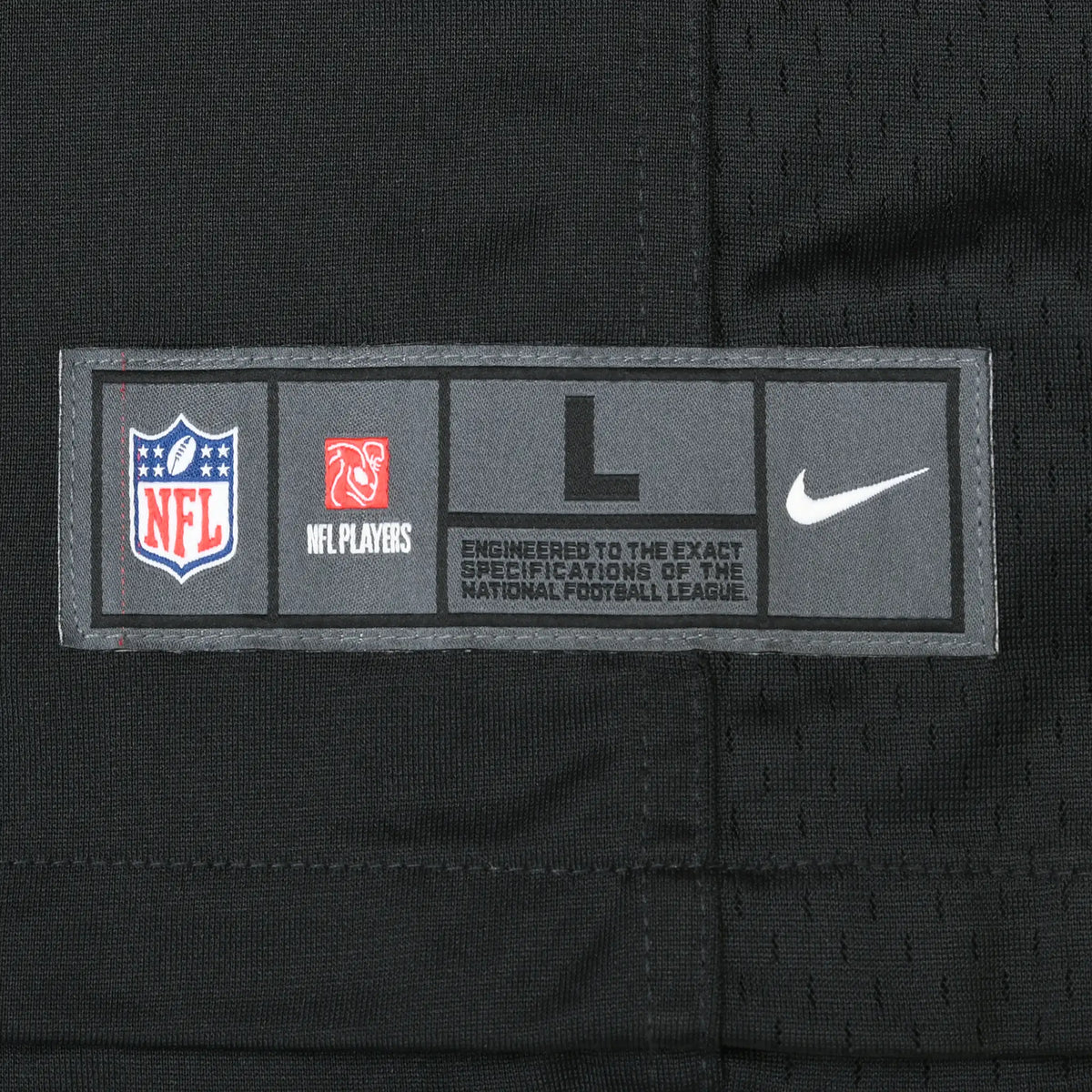 Close-up of NFL Players Nike size L jock tag stitched near the jersey hem