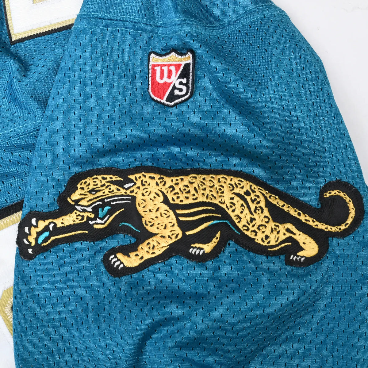 Embroidered Jacksonville Jaguars prowling jaguar sleeve logo and Wilson shield on teal mesh