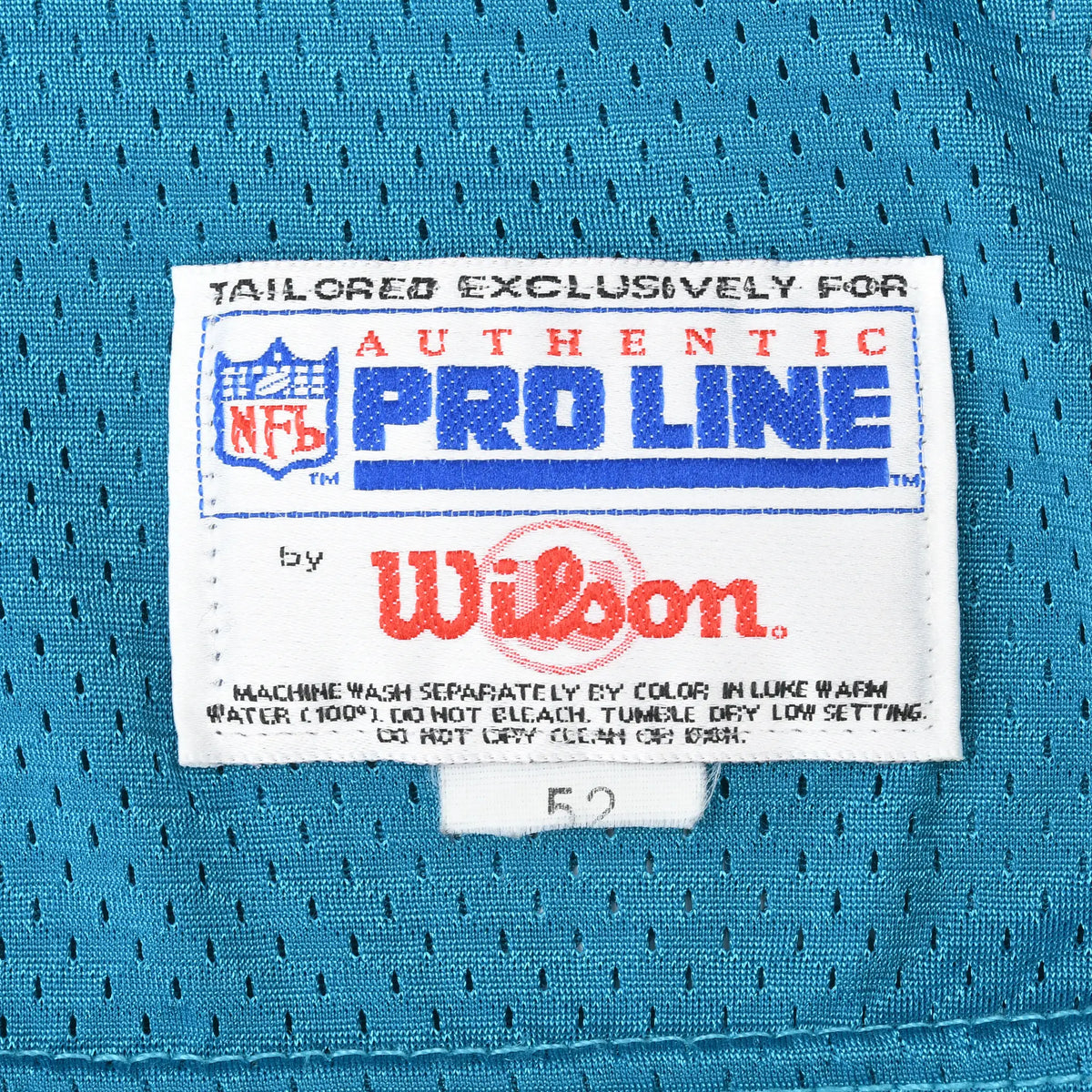 Close-up of NFL Pro Line by Wilson jersey label stitched on teal mesh