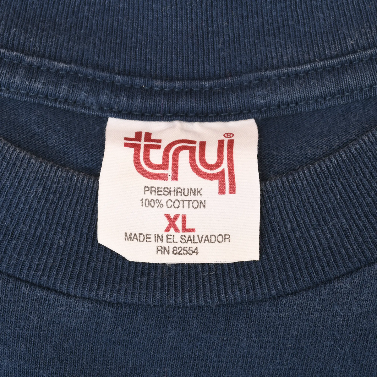 Tru-T XL neck tag on navy T-shirt showing preshrunk 100% cotton and made in El Salvador