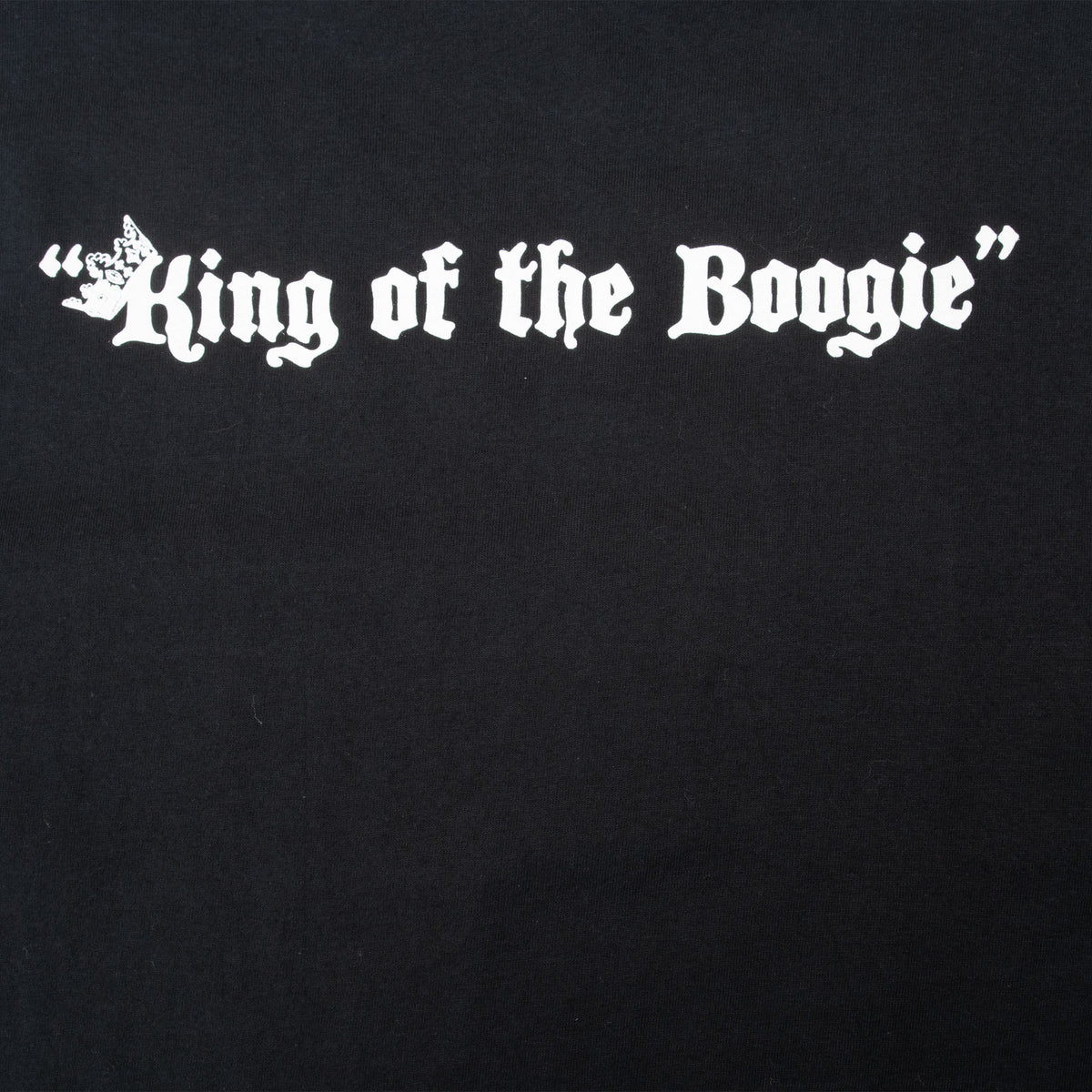 Close-up of white King of the Boogie back print on black fabric
