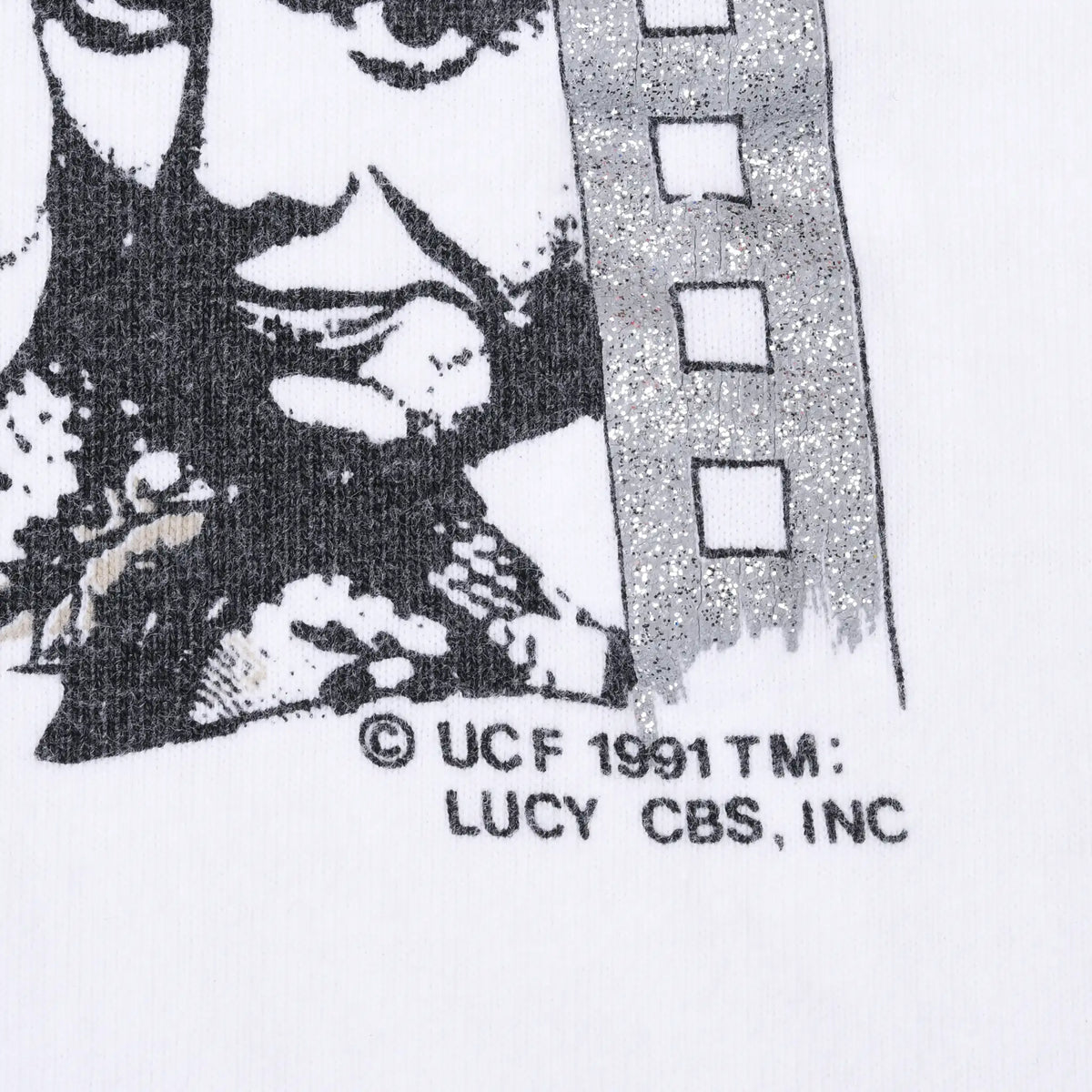 Close-up of 1991 UCF and Lucy CBS copyright text beside glittery filmstrip print